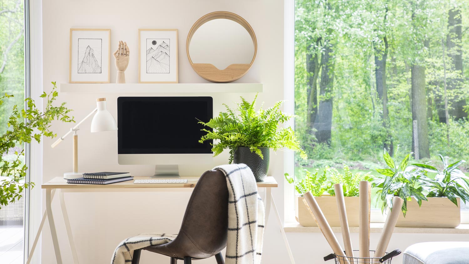 A desk with a window in the back overlooking nature