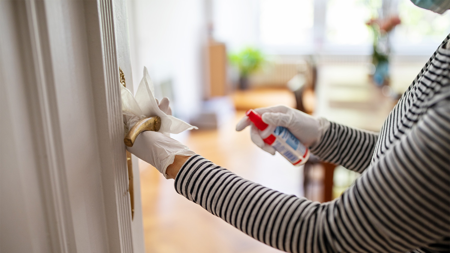 woman disinfecting door handle