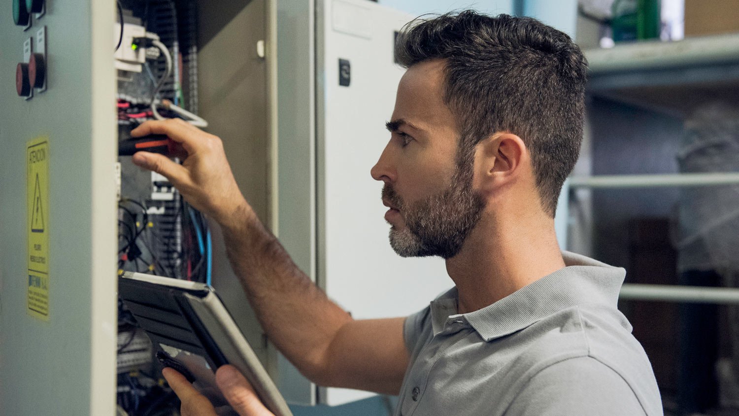 An electrician examining a circuit breaker panel