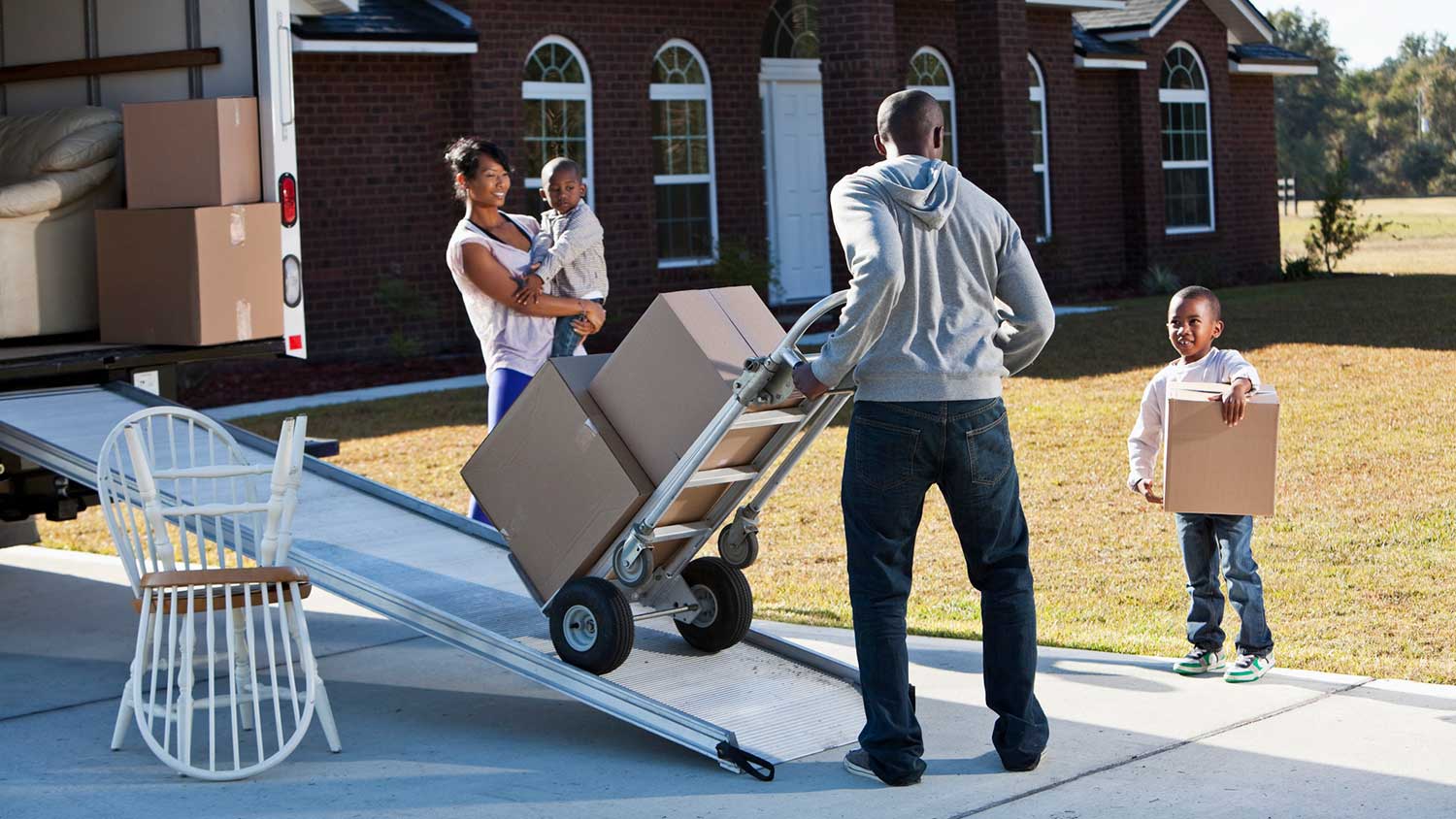 Son helping dad load boxes into a moving truck