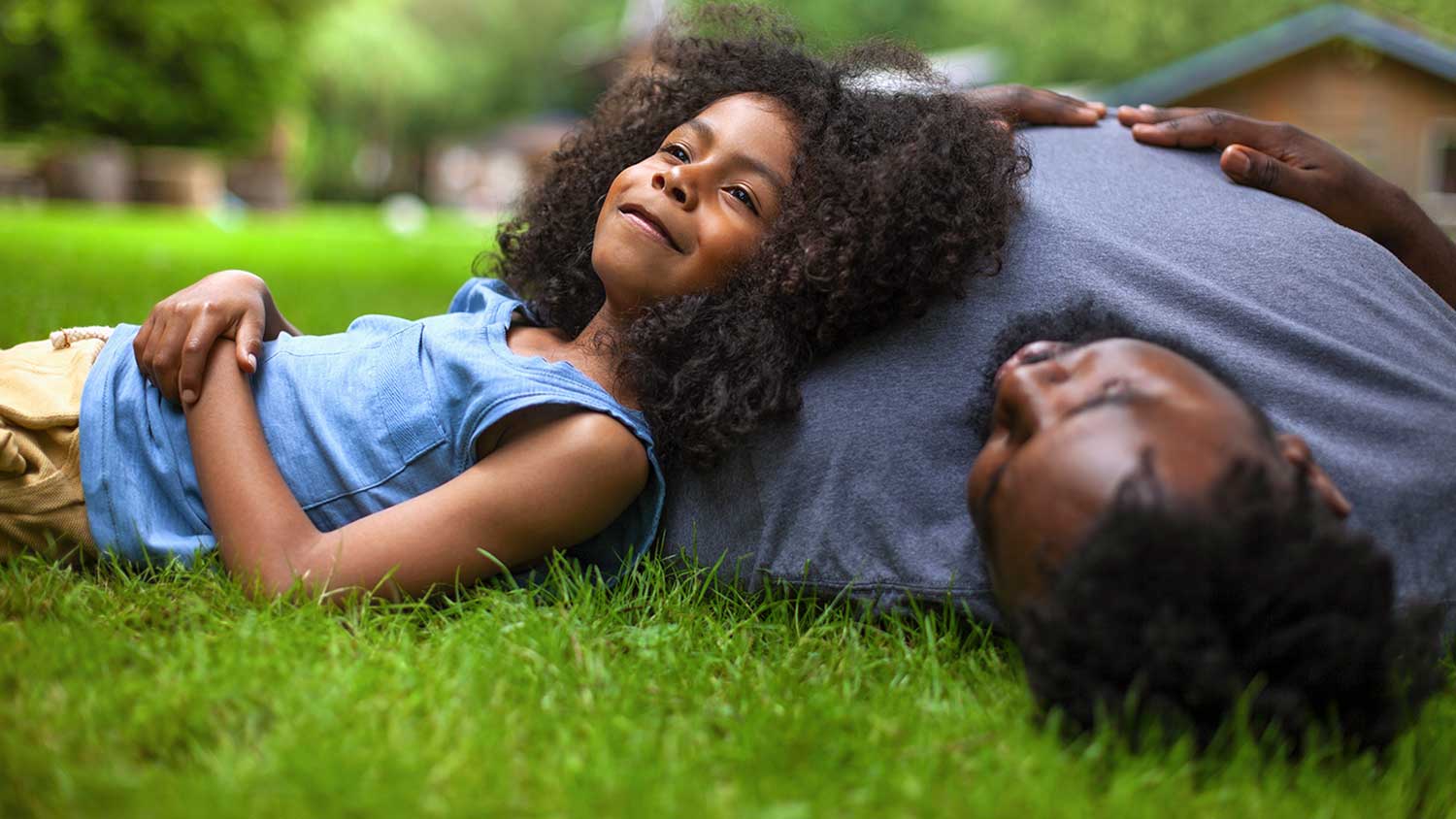 Father and child laying on grass