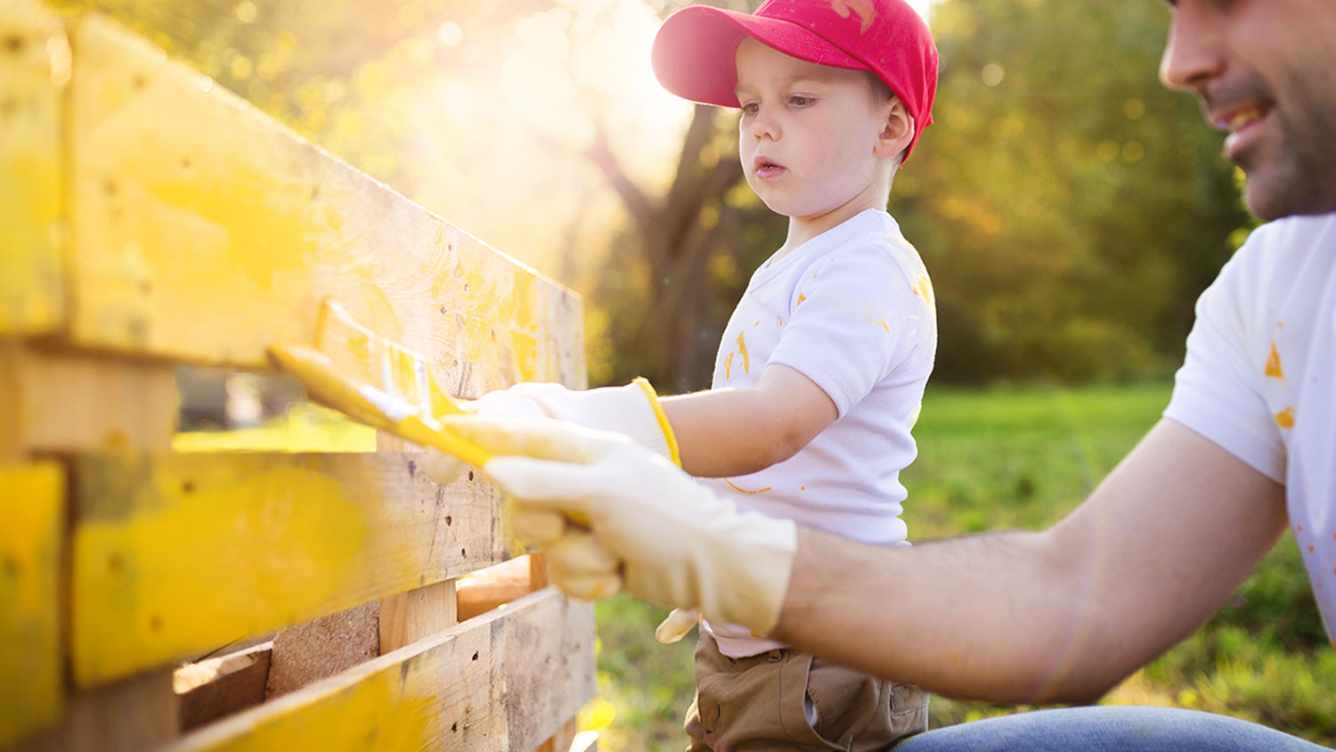 Father and son painting fence