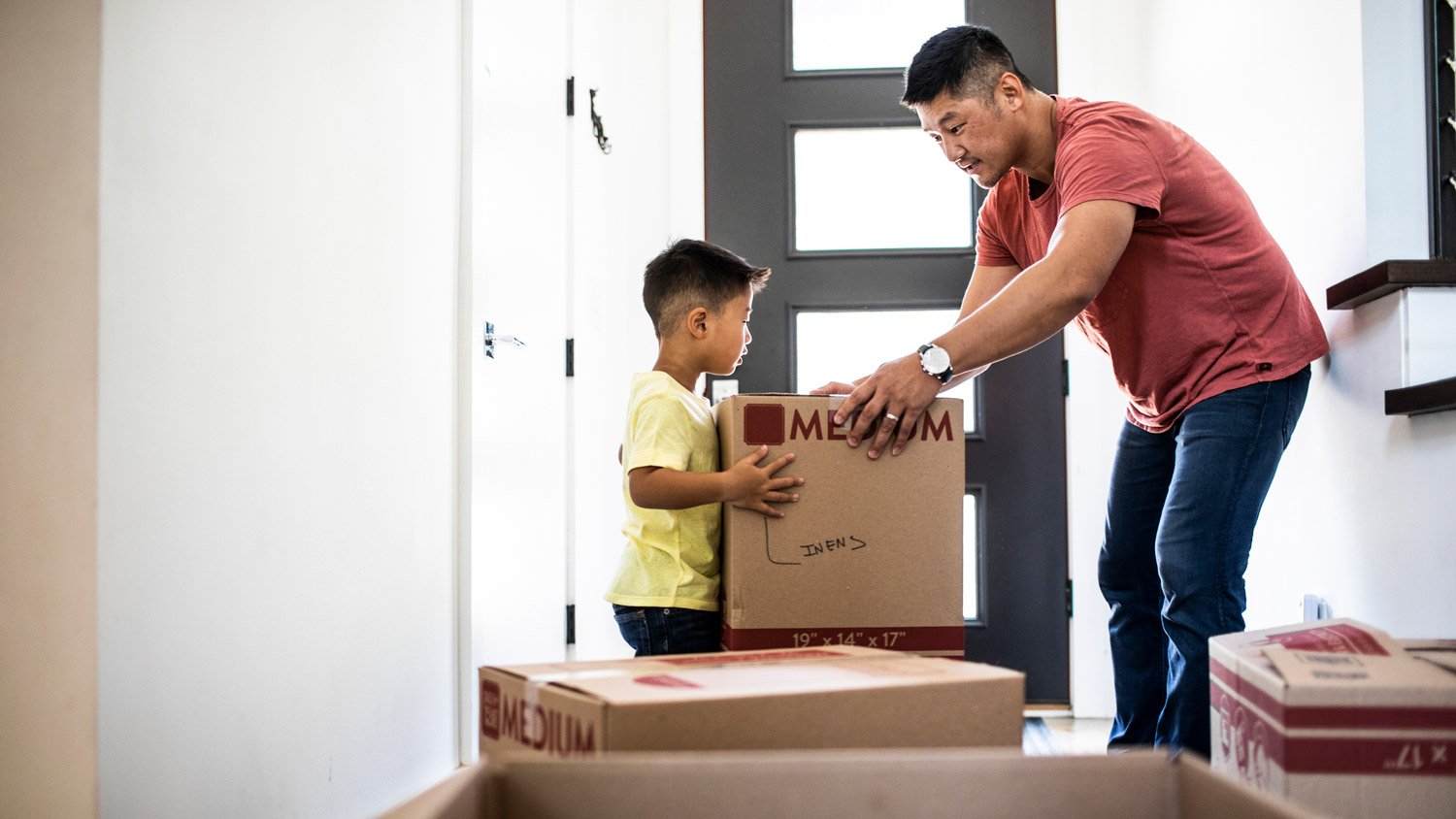 A father and his son moving cardboard boxes