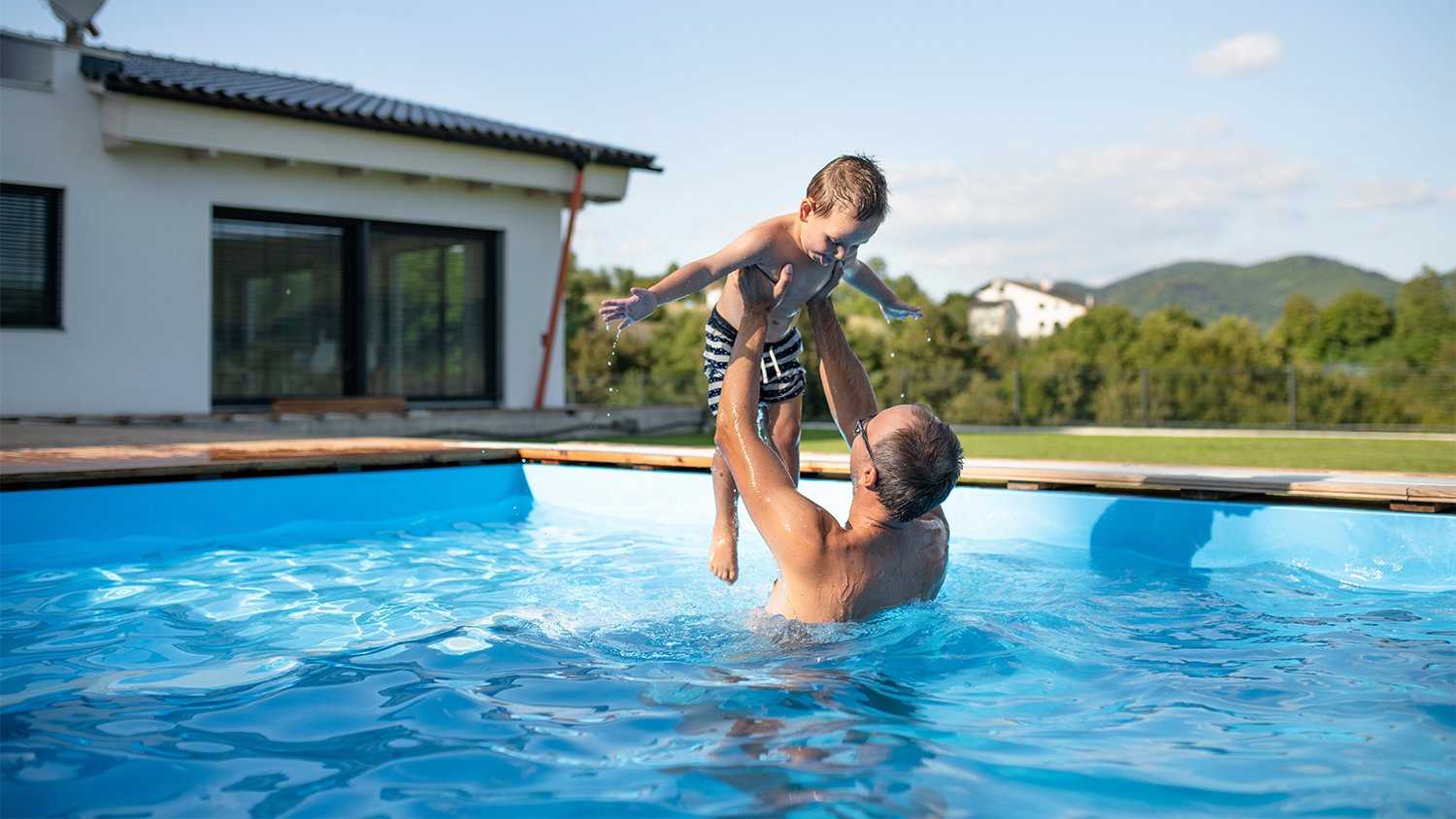 man playing with his son in the pool