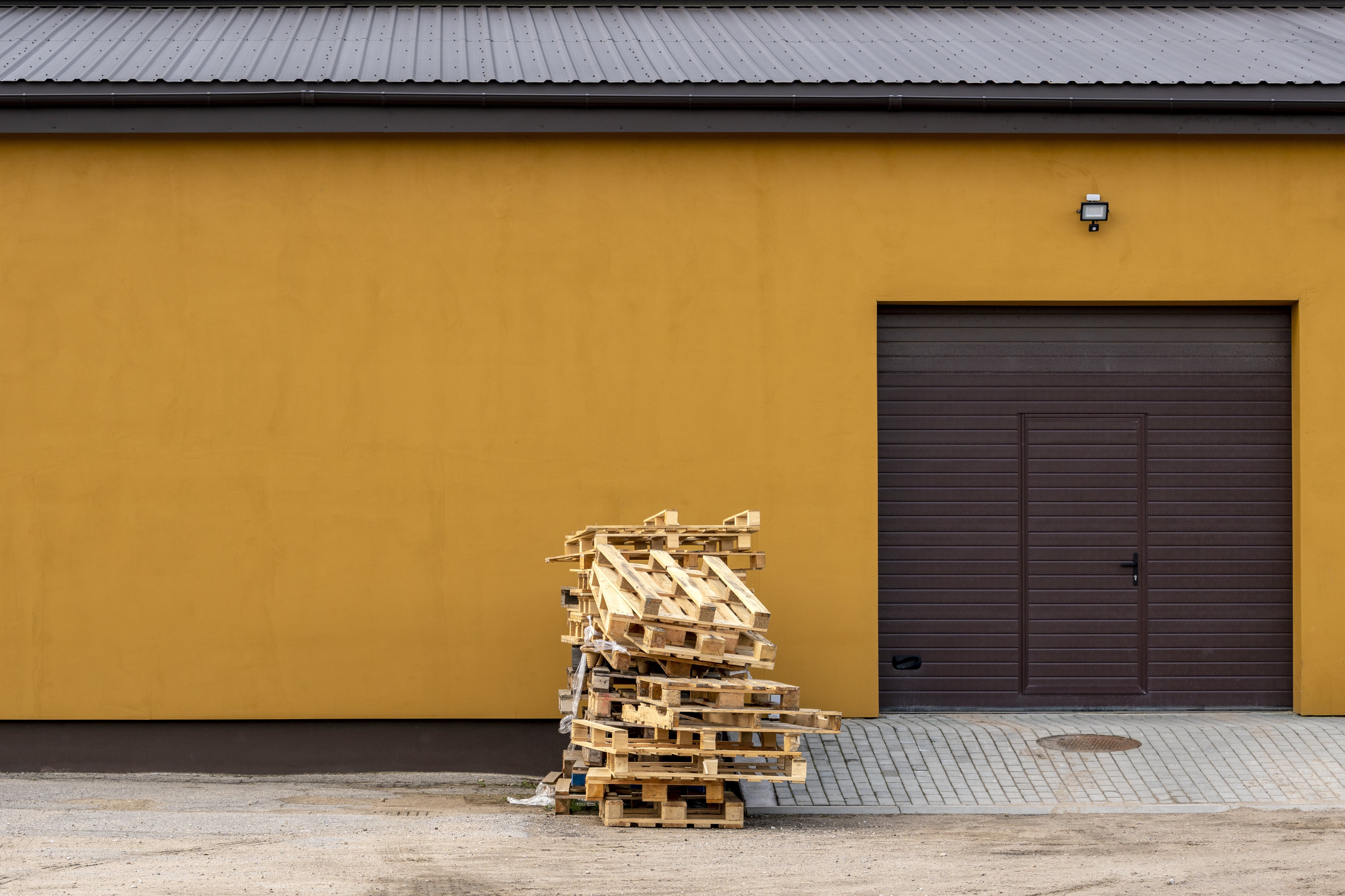 Shipping pallets stacked outside business’ garage door