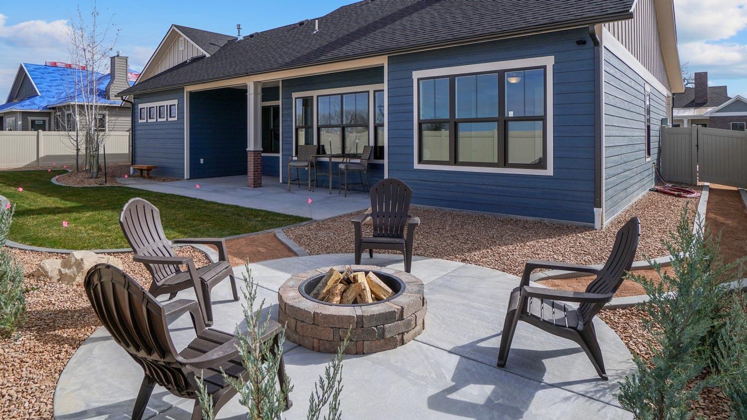 A fire pit with patio furniture in the backyard of a house