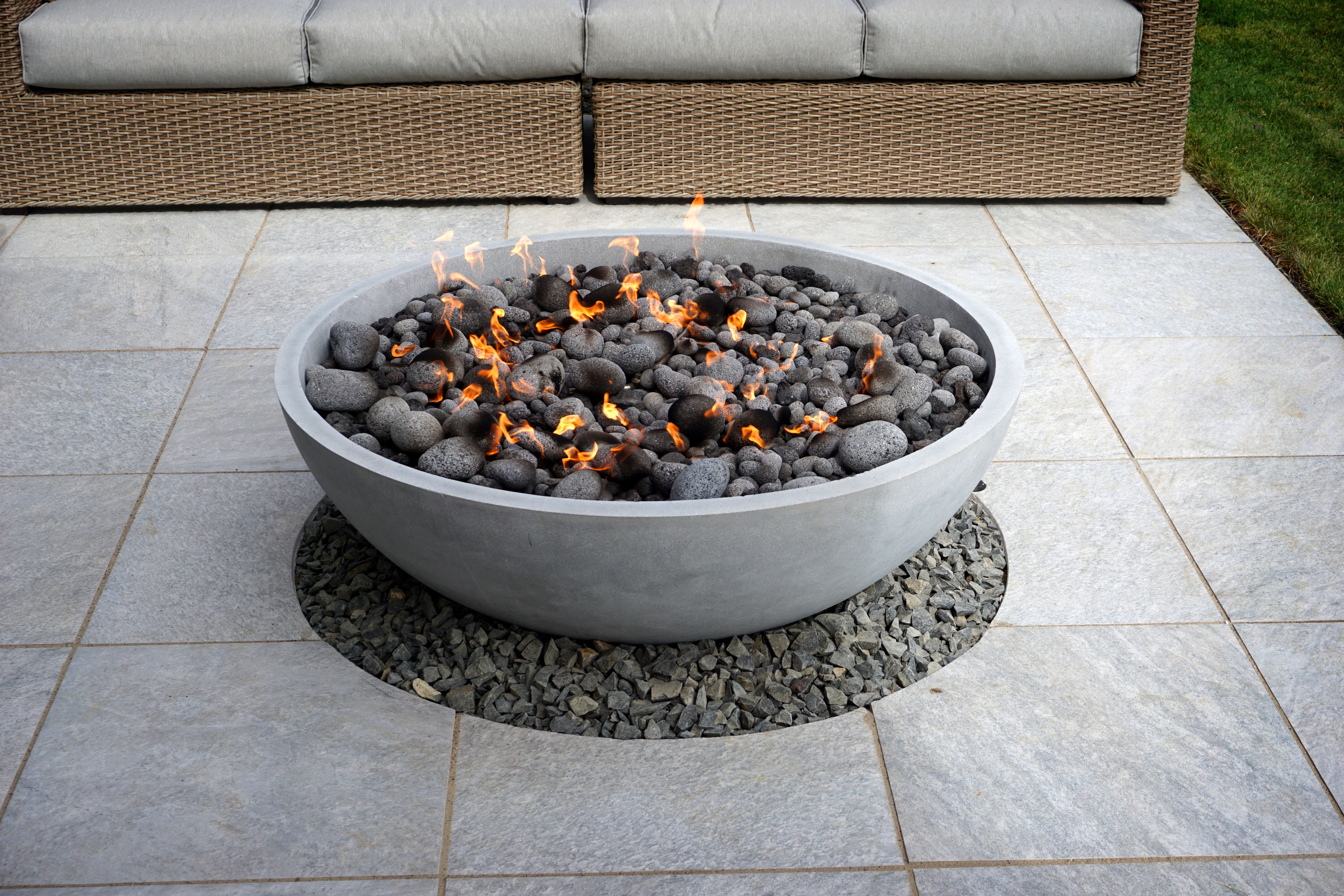 A contemporary style fire pit bowl made with molded cement