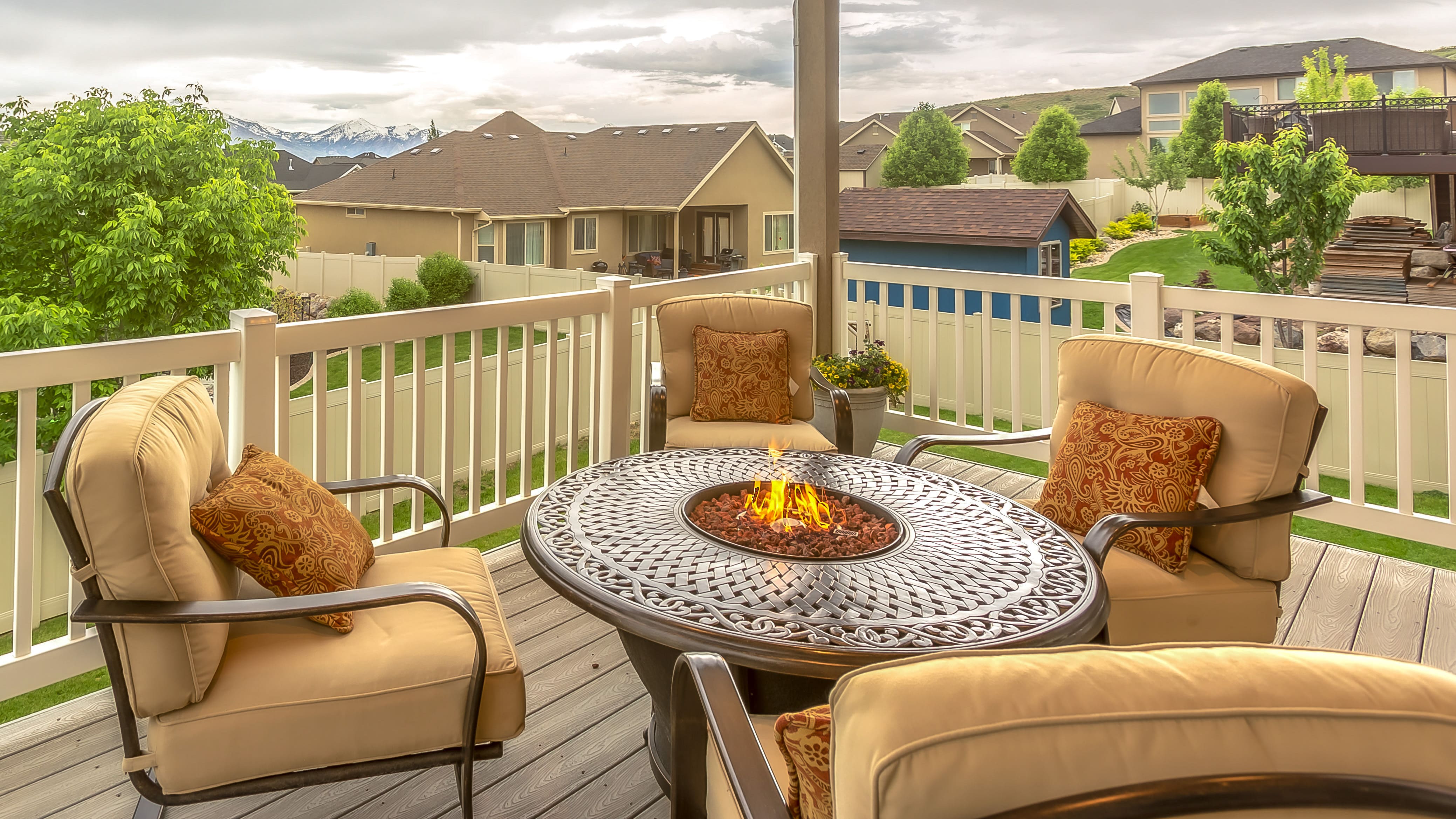 A propane-powered fire pit table with cushioned seating on a second-story patio