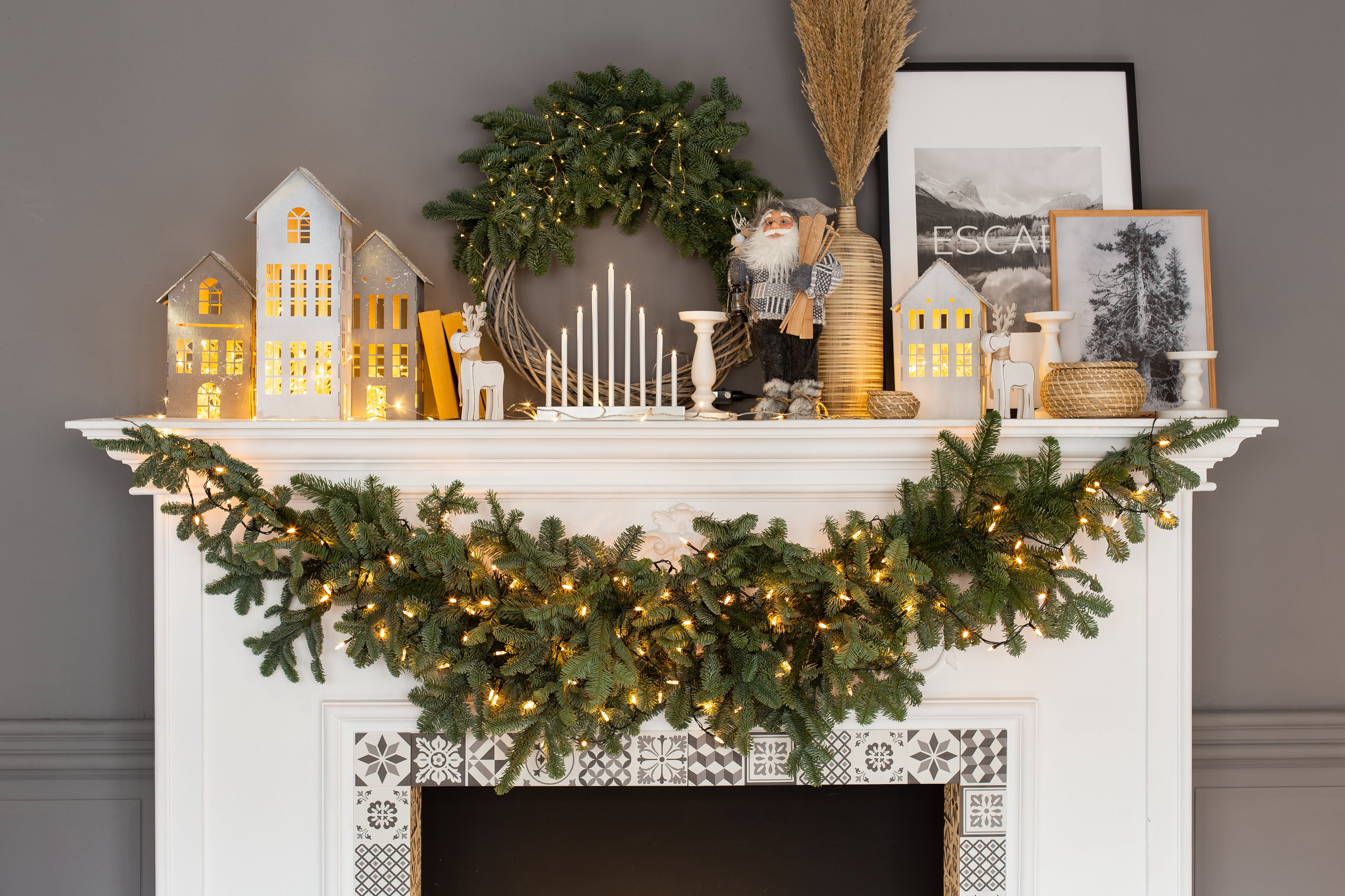 White fireplace mantel decorated with Christmas decor 