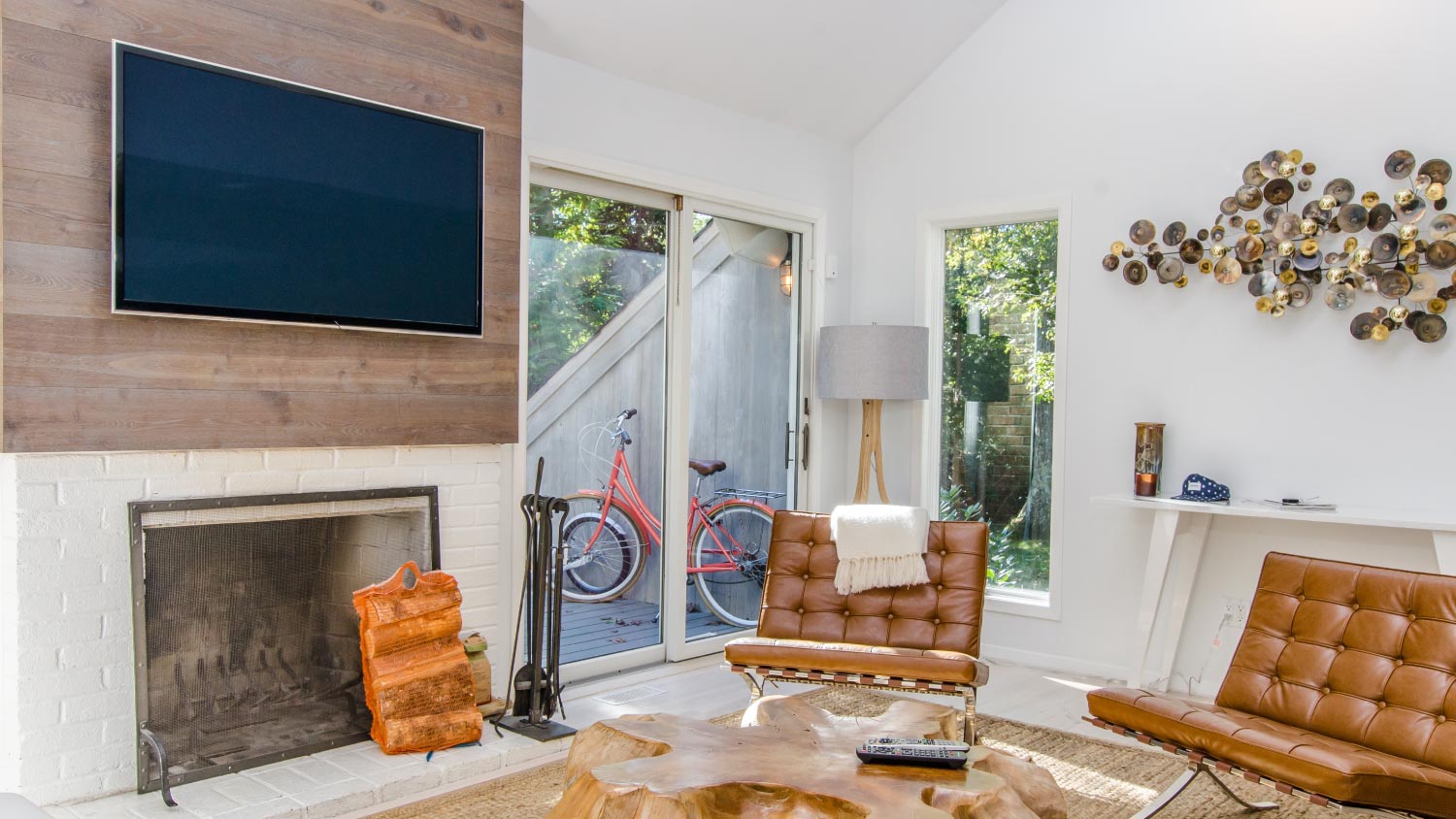 living room with tall windows and the TV above the fireplace