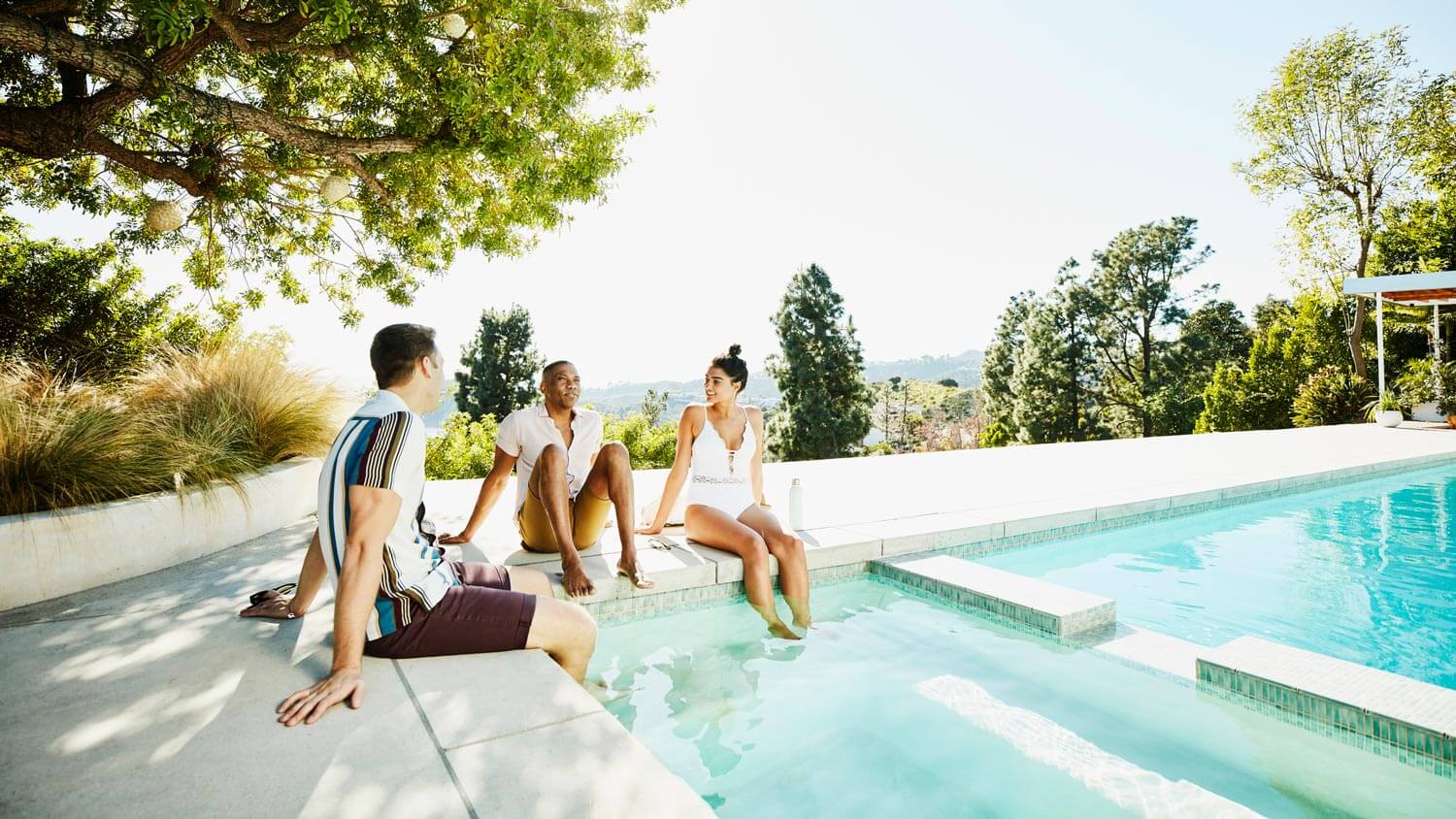 Group of friends hanging out by the pool