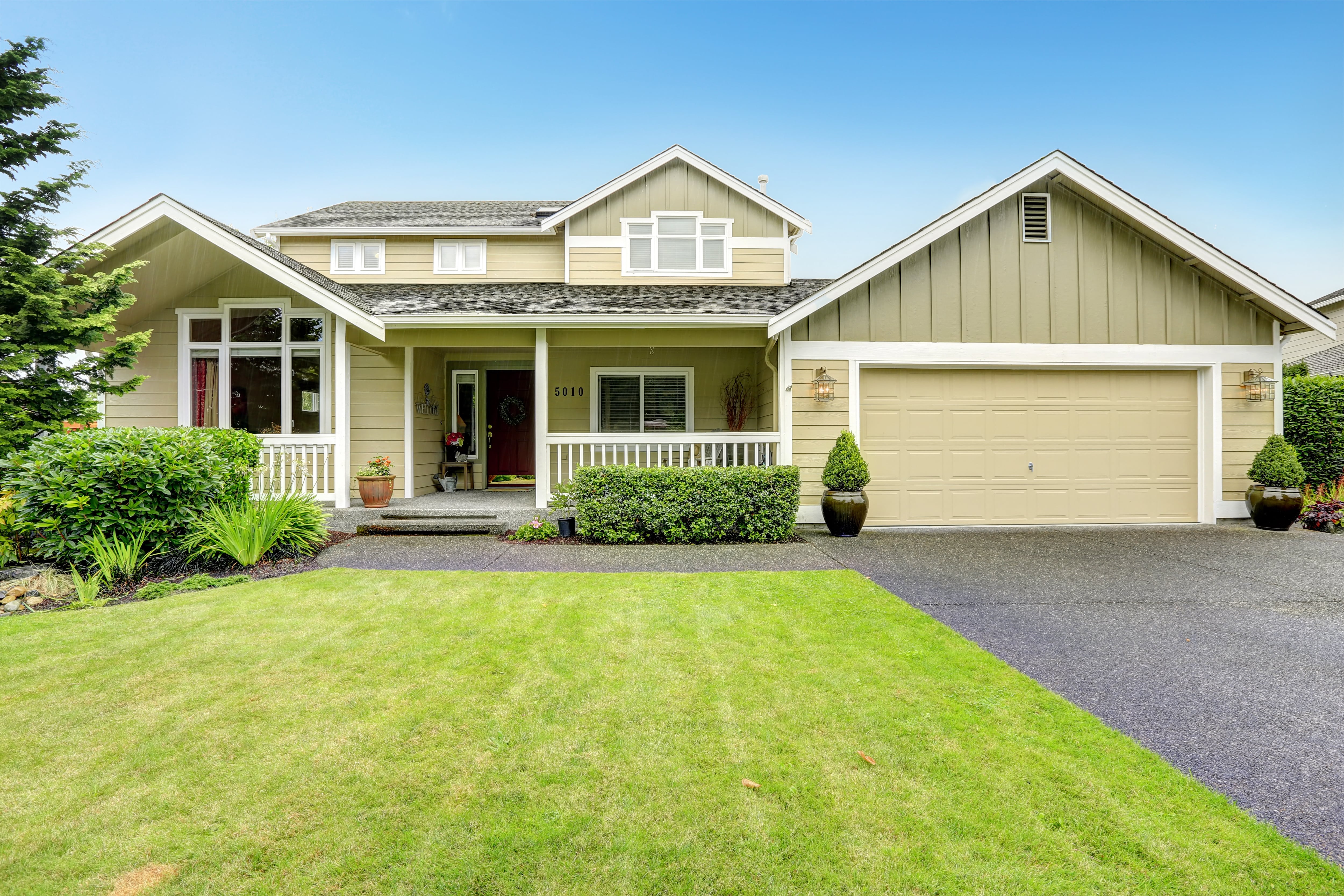 Tan house and trimmed green lawn 