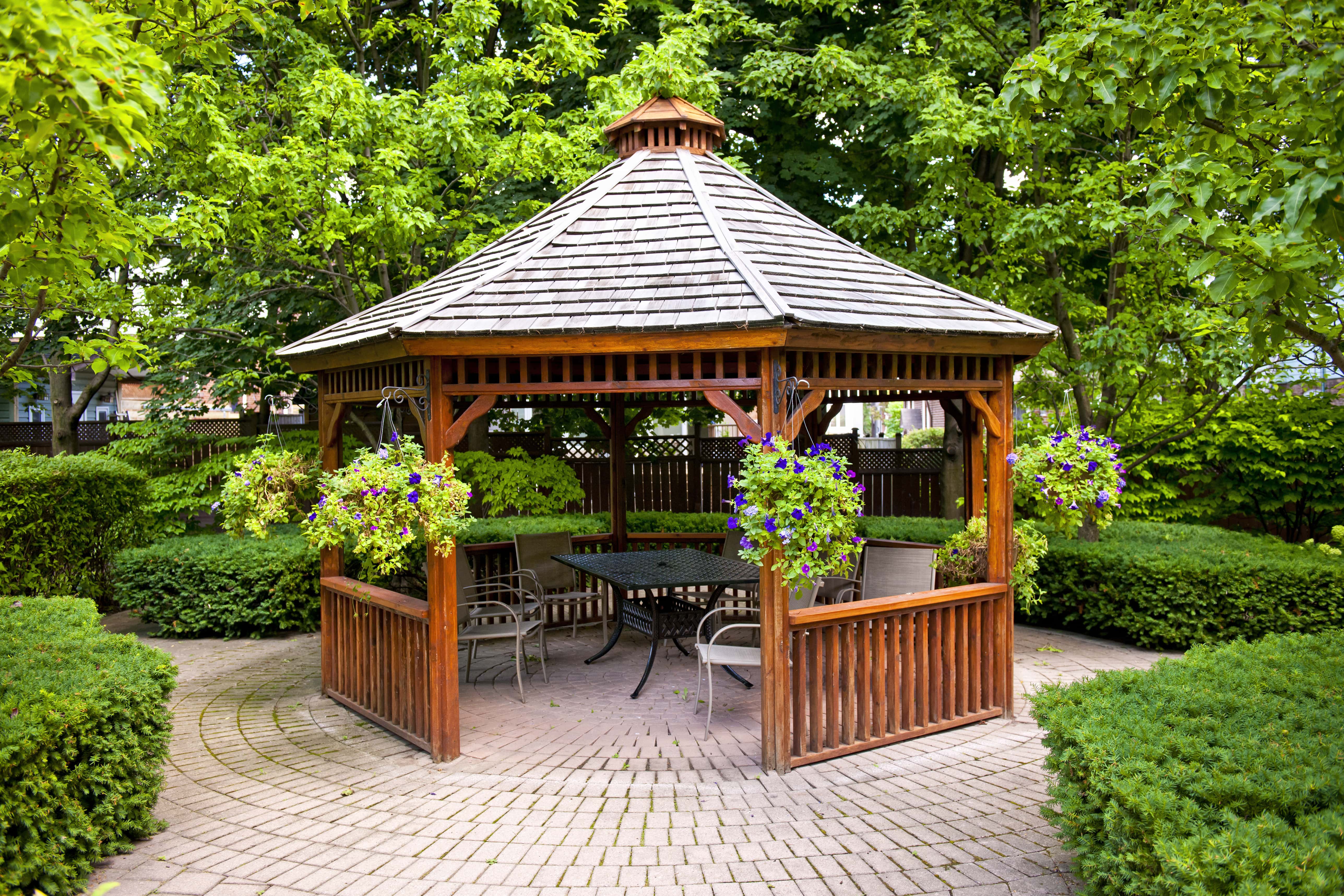 Gazebo in backyard with outdoor furniture underneath