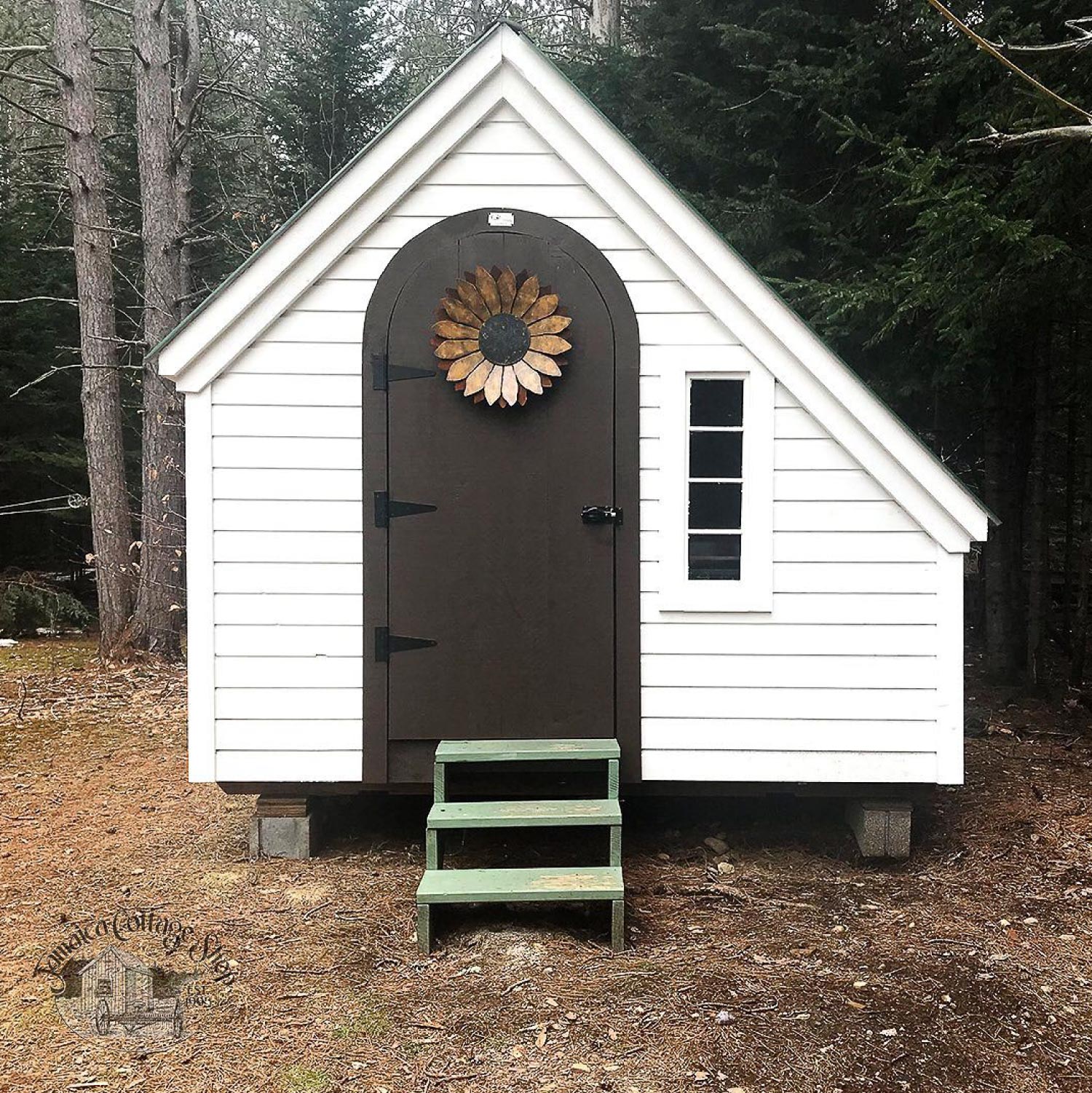 A garden shed with white wood siding