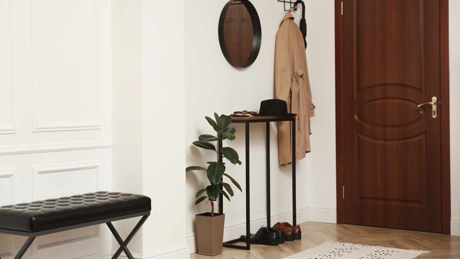 A hallway with stylish furniture and pairs of shoes by the door