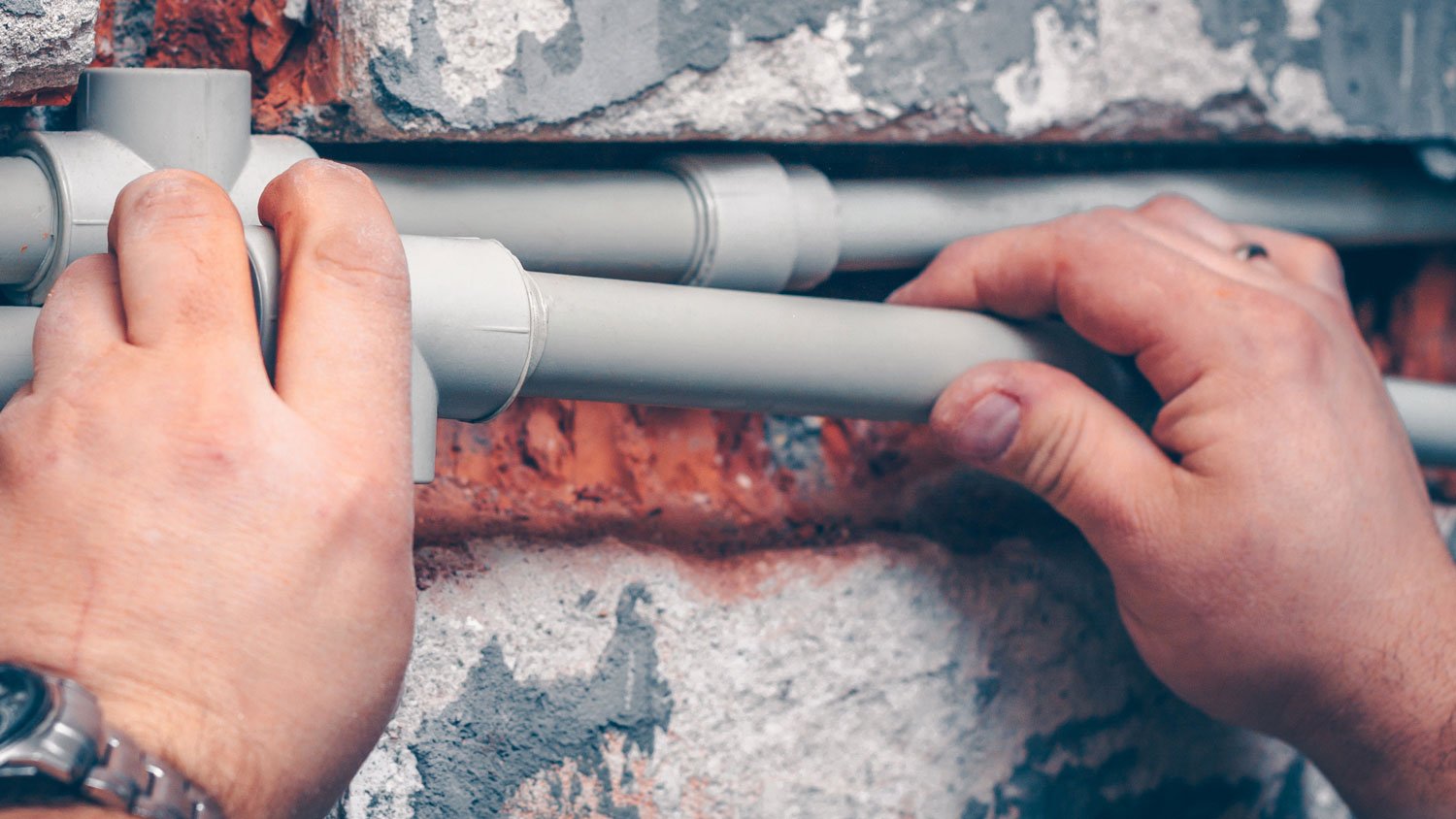 Close-up of hands connecting pex pipes for plumbing