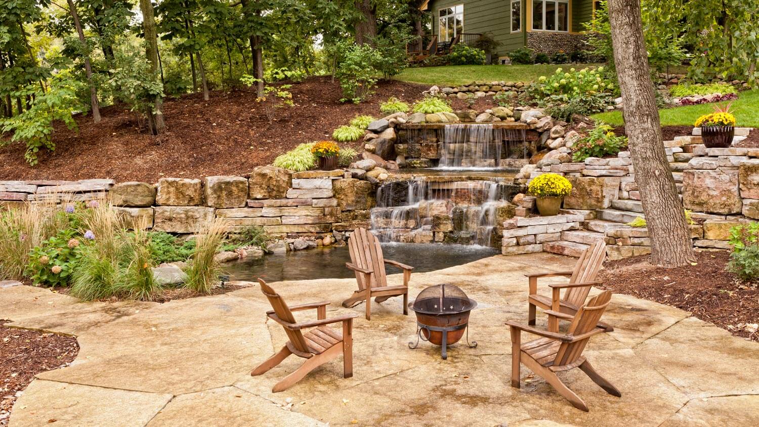 Hardscaping a backyard with a waterfall and a fire pit
