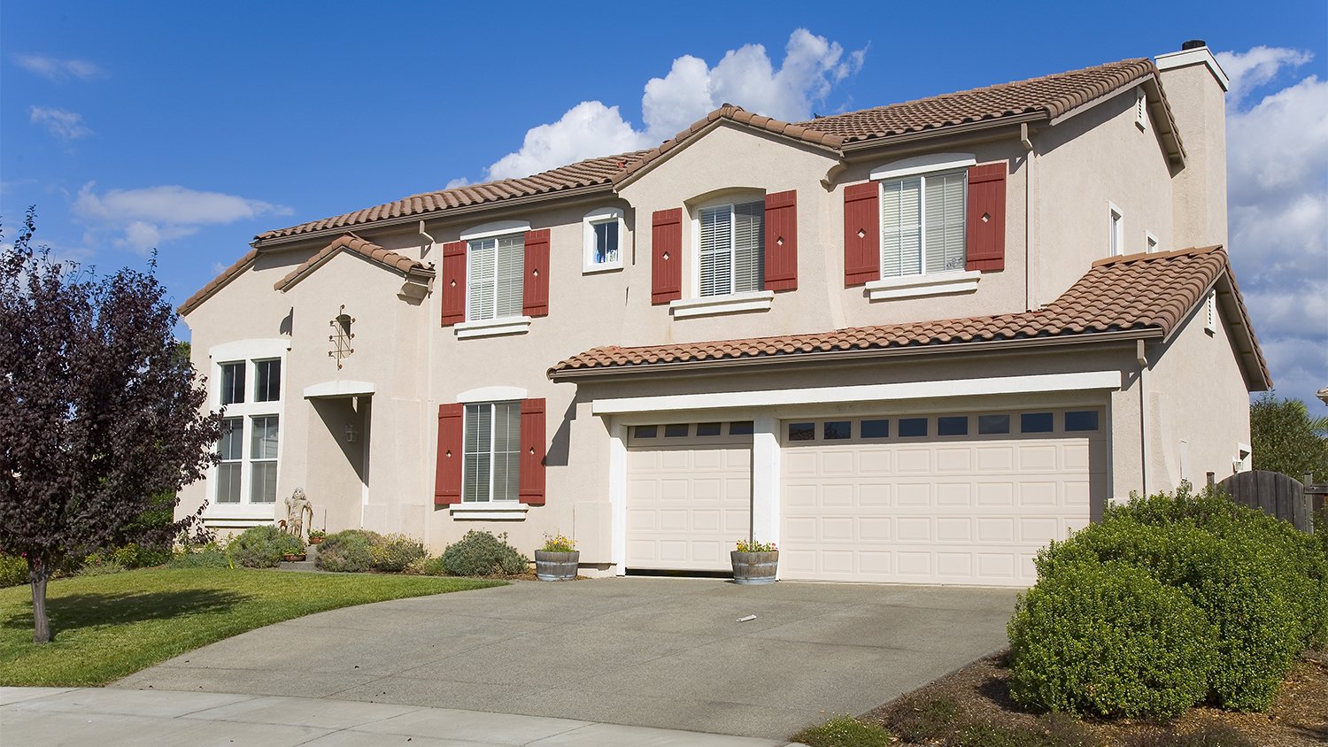 beige home with concrete driveway  