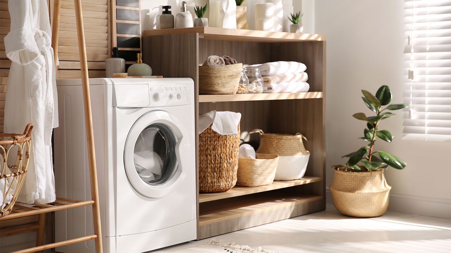 washing machine next to a shelf with towels
