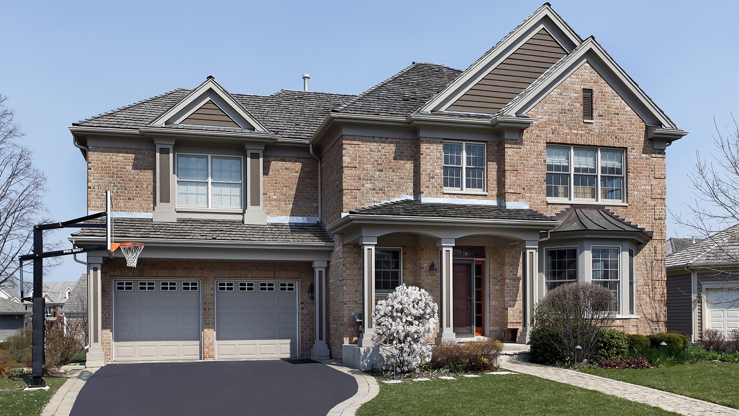 brick home with asphalt driveway
