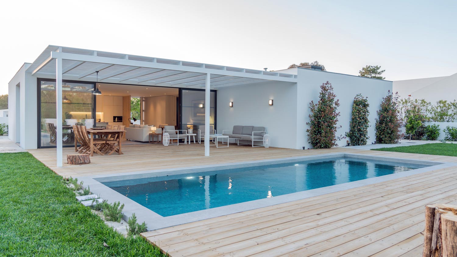 A house’s backyard with a wooden deck and a pool