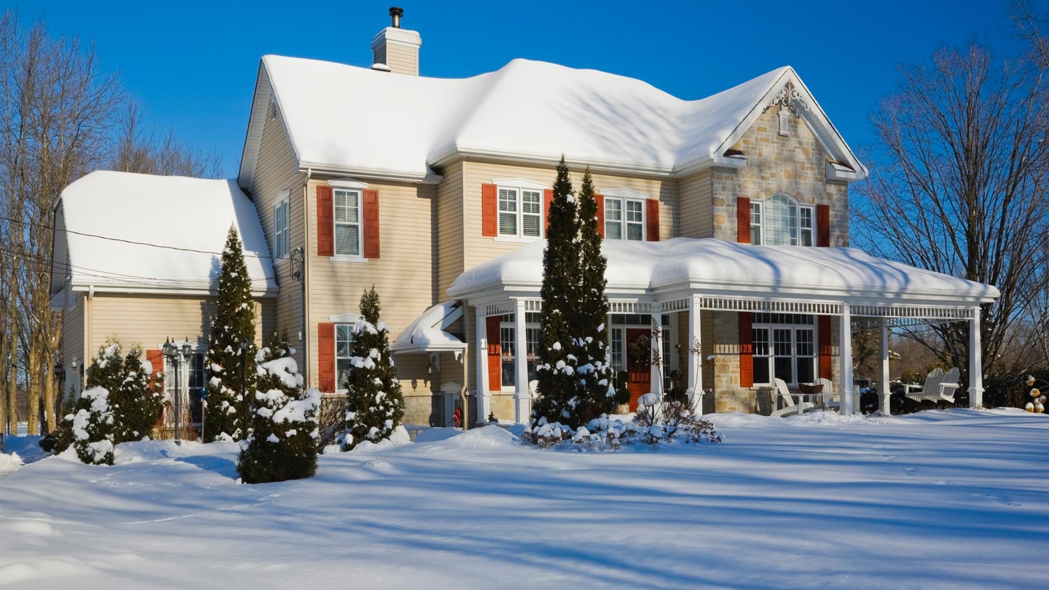 A house covered with snow on a sunny winter day