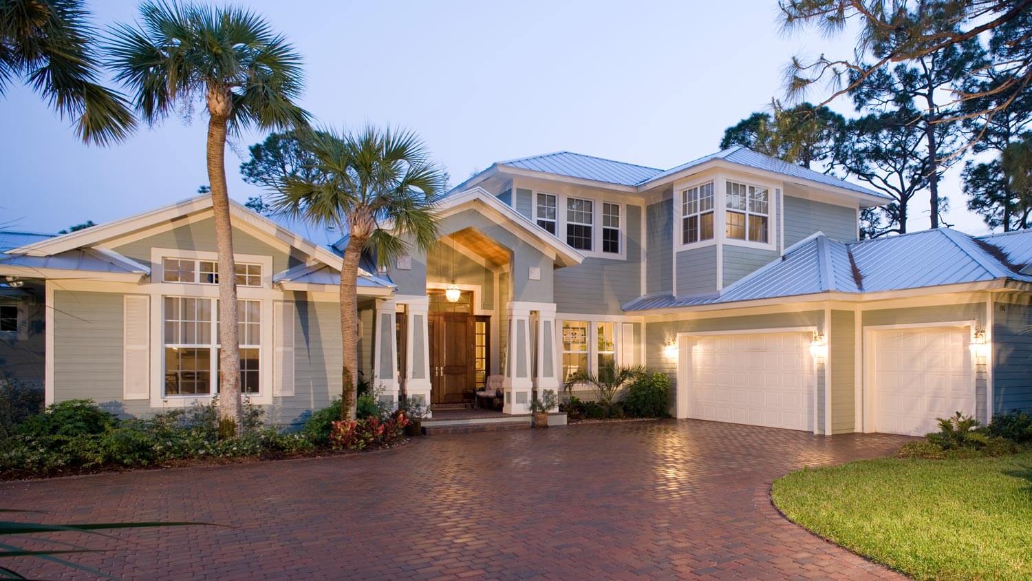 A house at dusk with the outdoor lights on