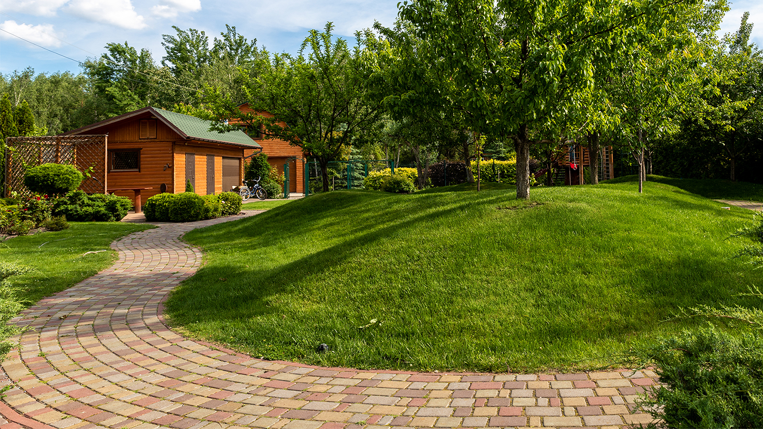 house with lush grounds and mosaic brick path