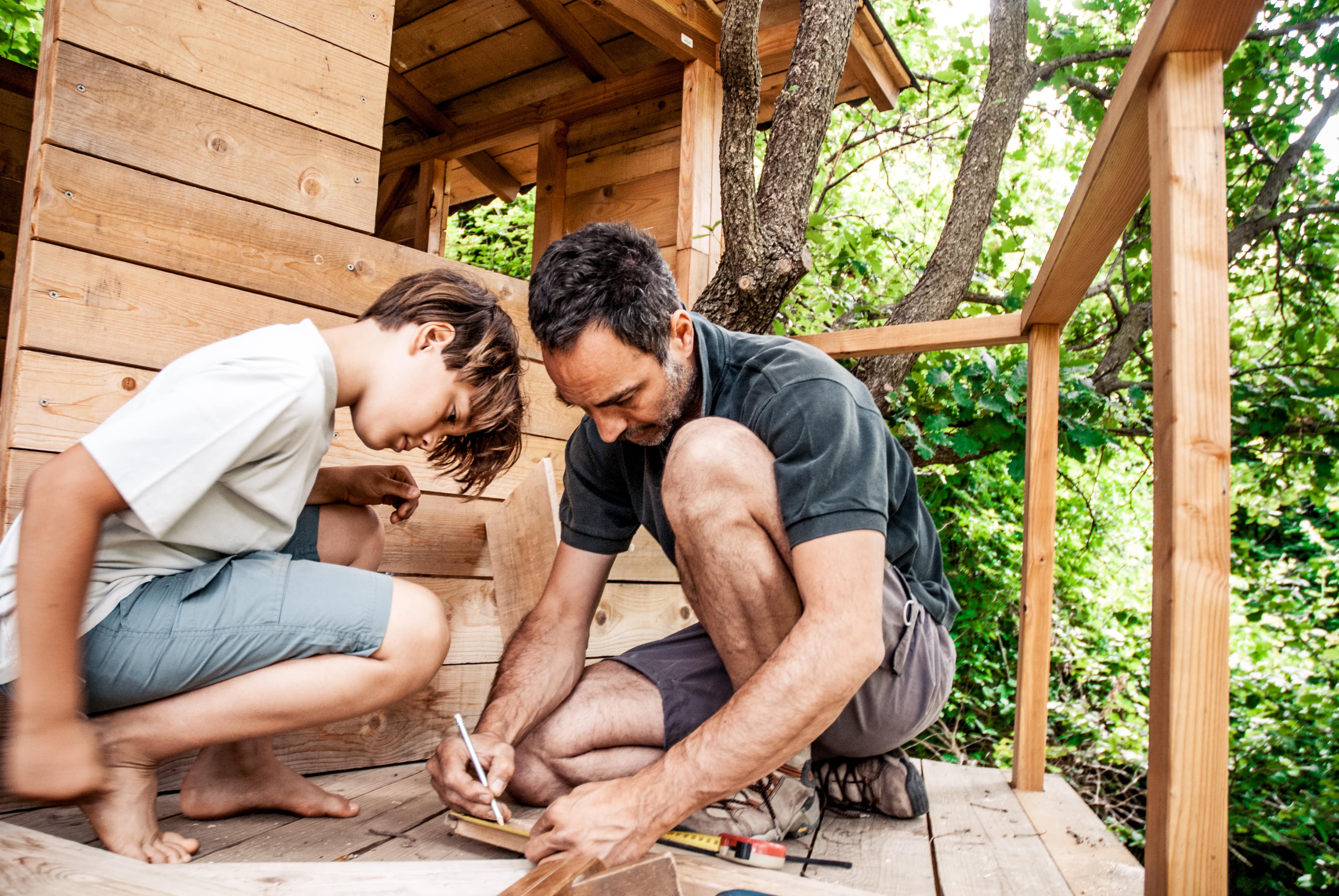 A father and son building a treehouse together