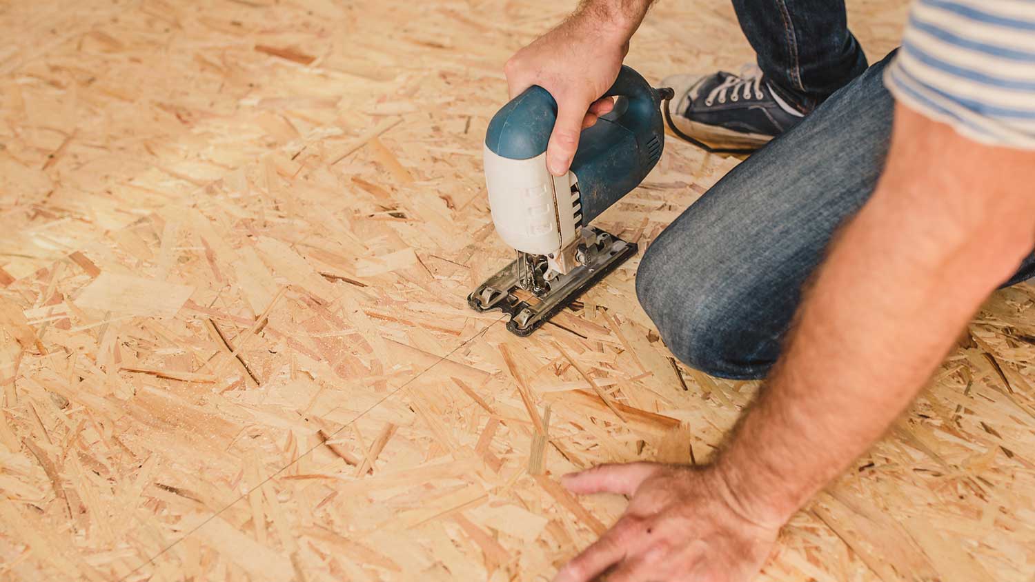 Man using plywood to install subfloor