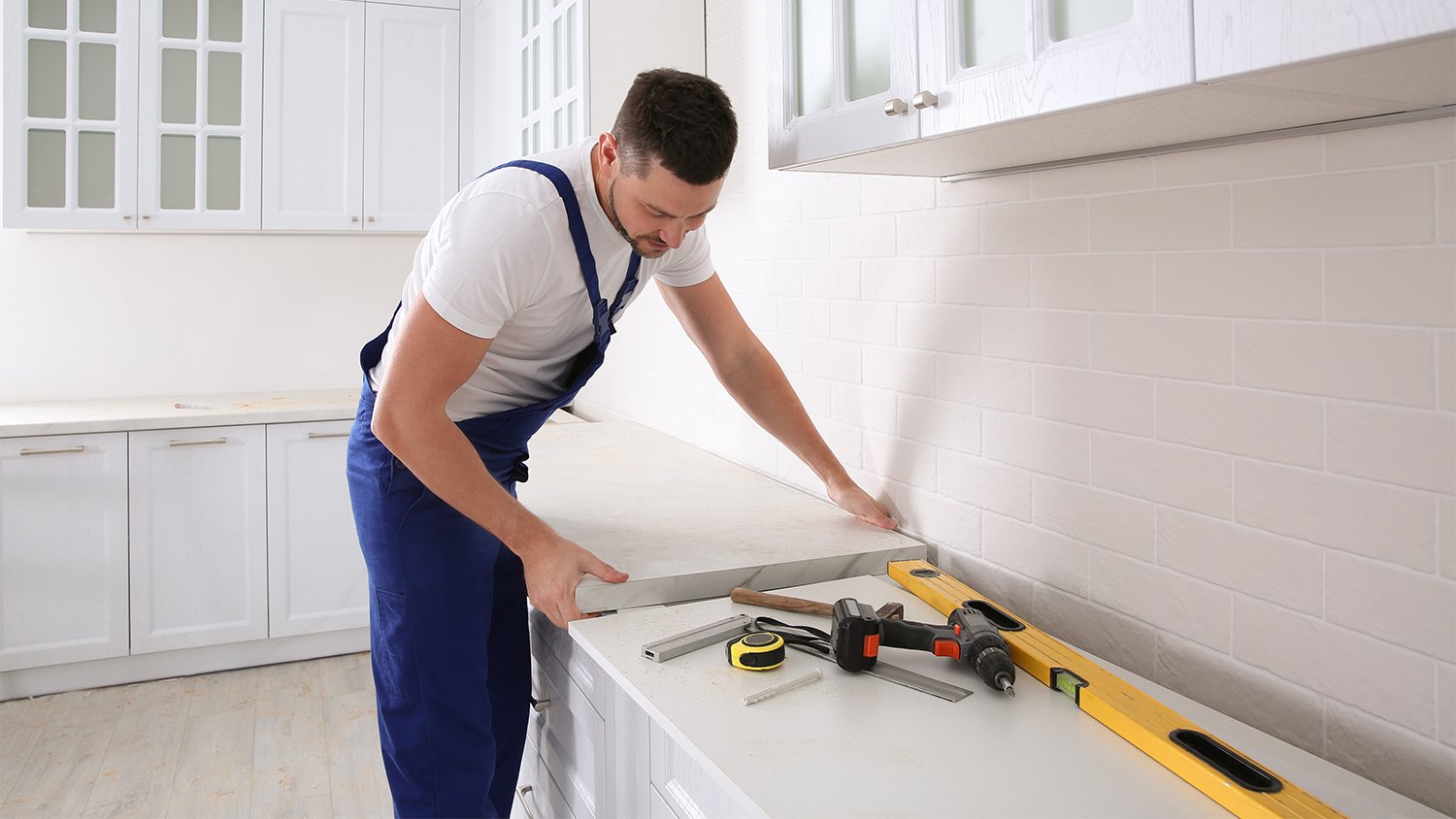 contractor installing new countertop in kitchen   