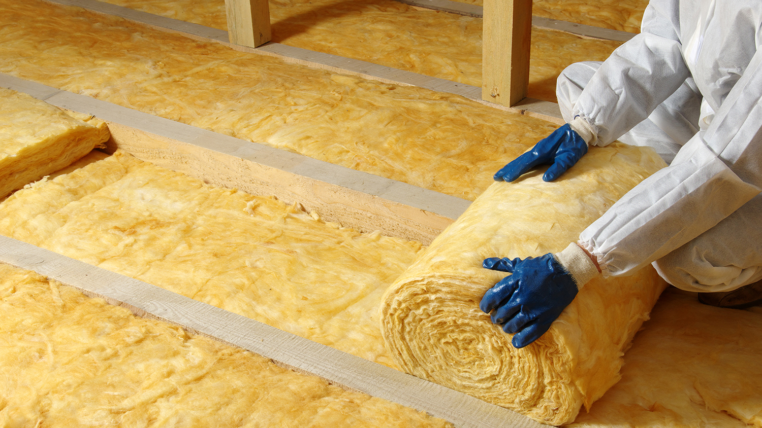 worker adding insulate to attic