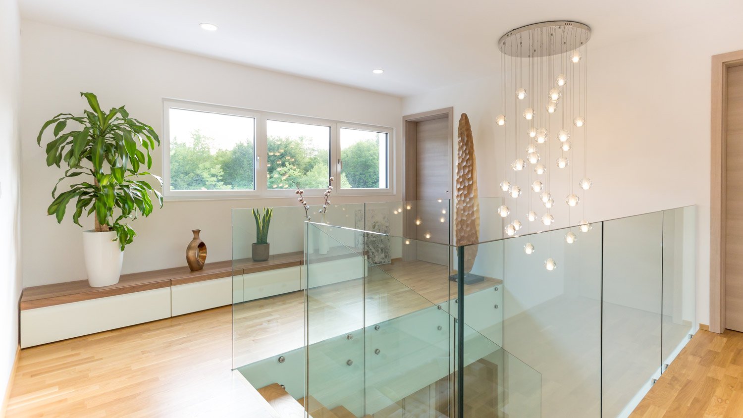 The interior of a house with an intricate lighting fixture above the stairs