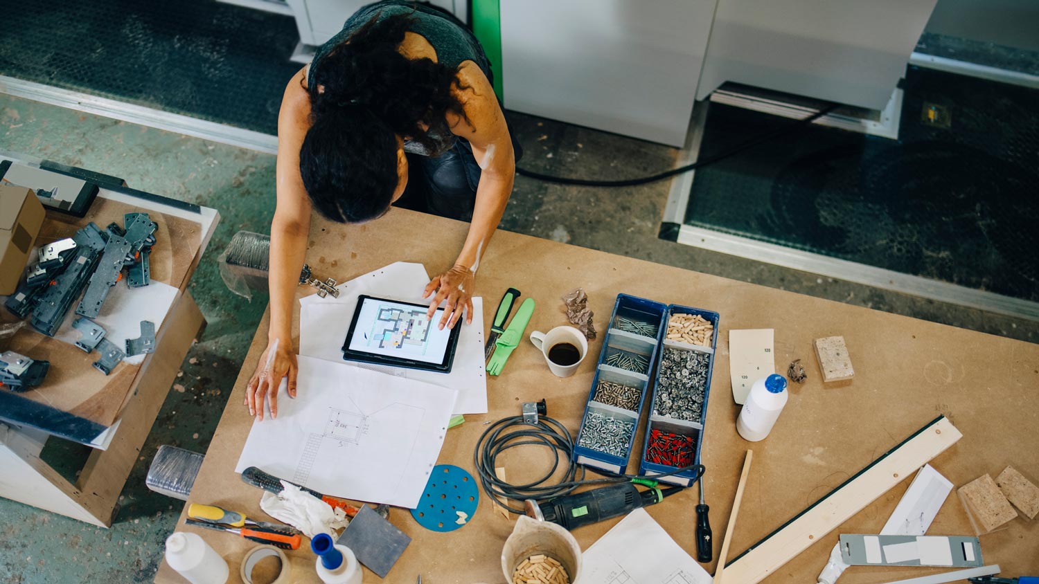 High angle view of a journey person using a tablet at her work