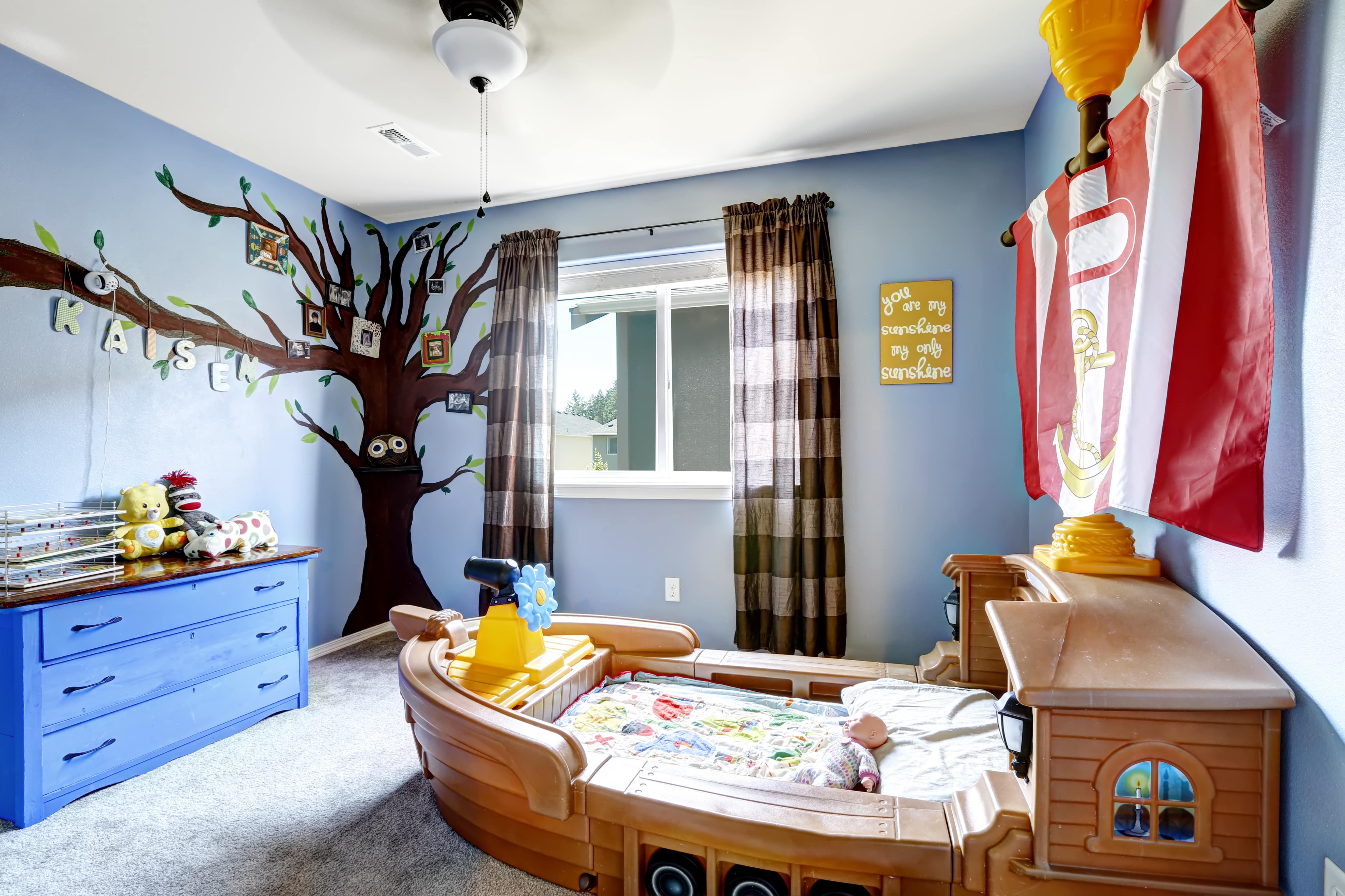 Cheerful kids room with boat bed and gallery wall