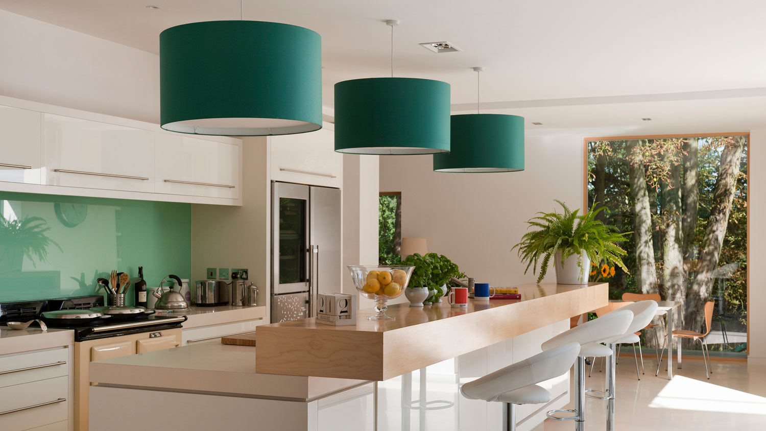 A kitchen with an emerald wall and light fixtures