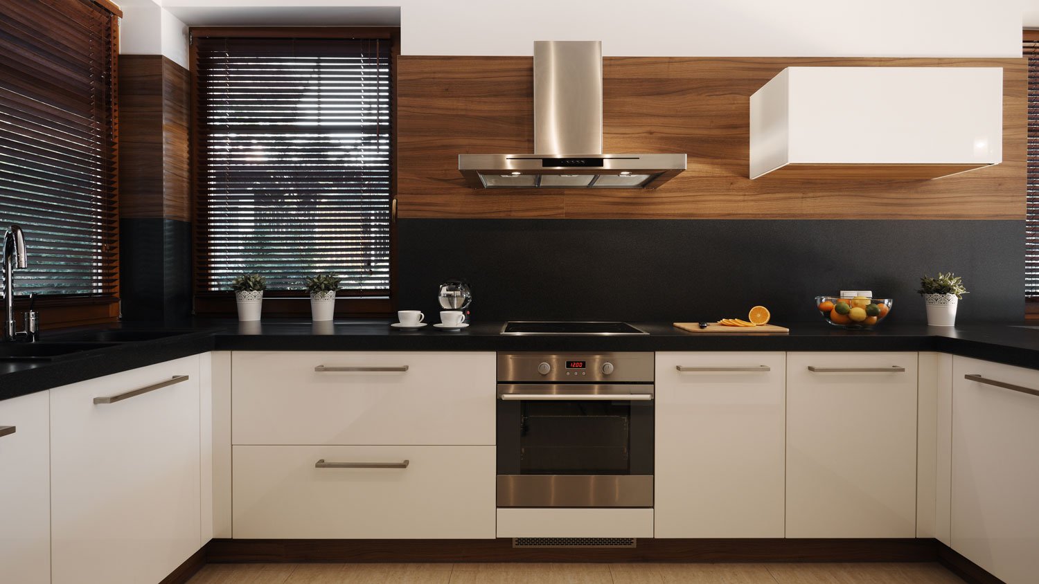 A kitchen with white cabinets and a black wall