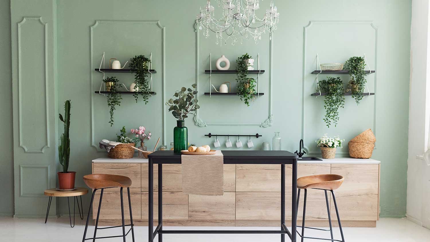 Kitchen with green wall and light wooden cabinets