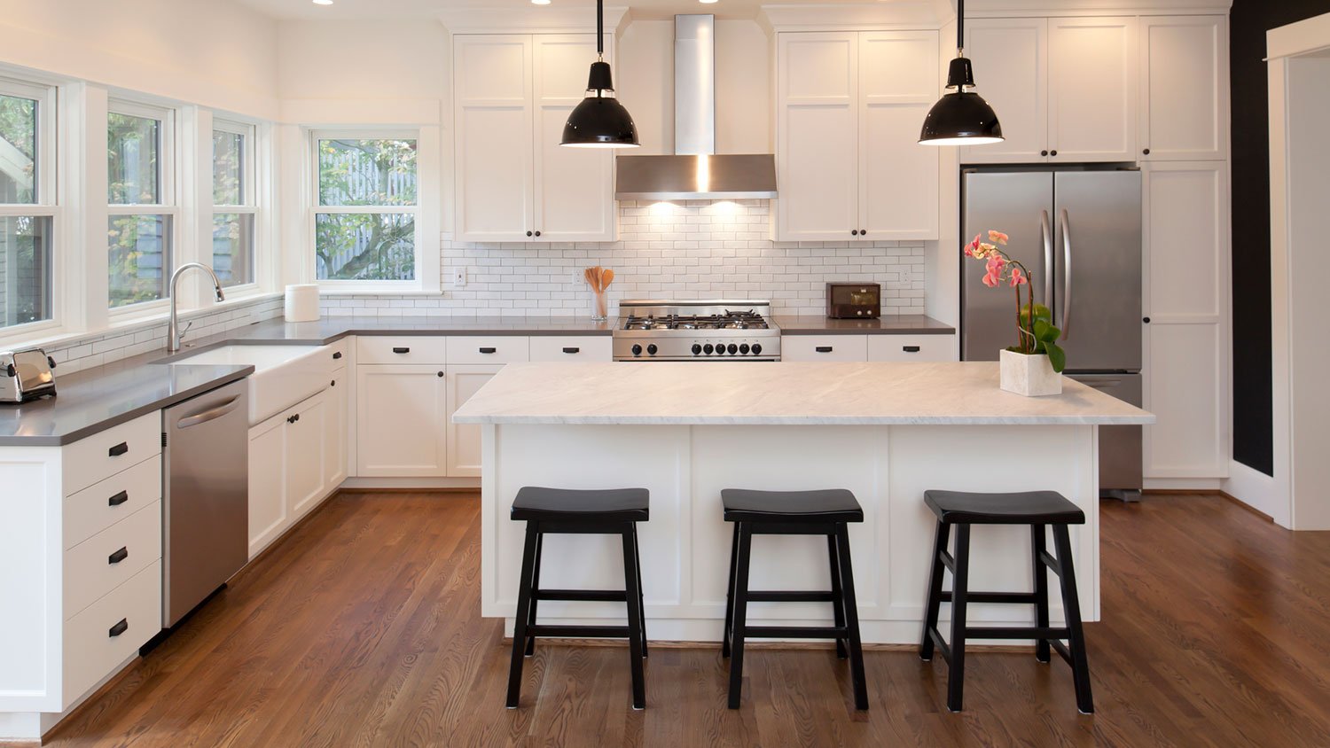 New kitchen with white cabinets and black bar stools