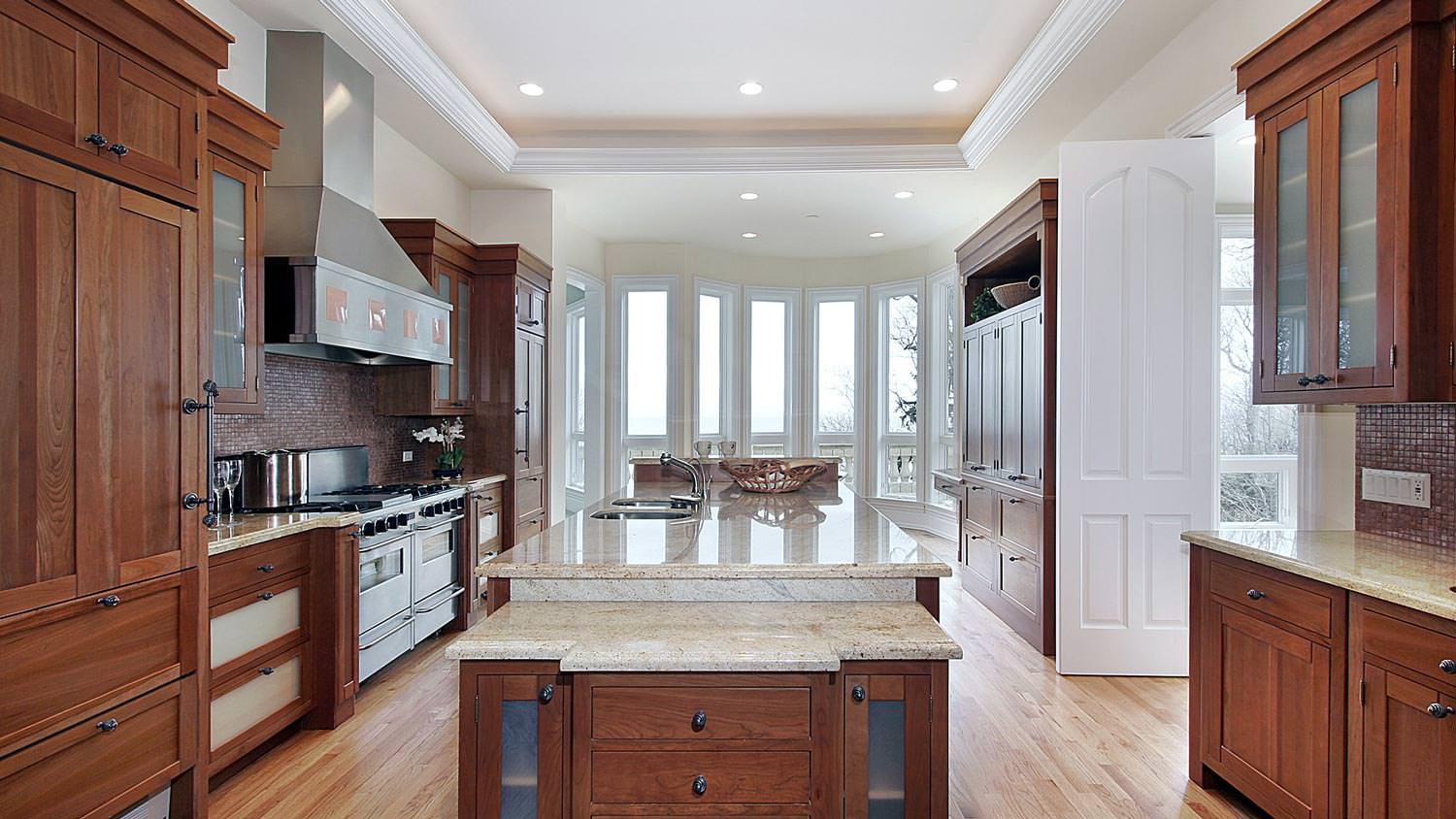 A kitchen with wooden cabinets and recessed lighting