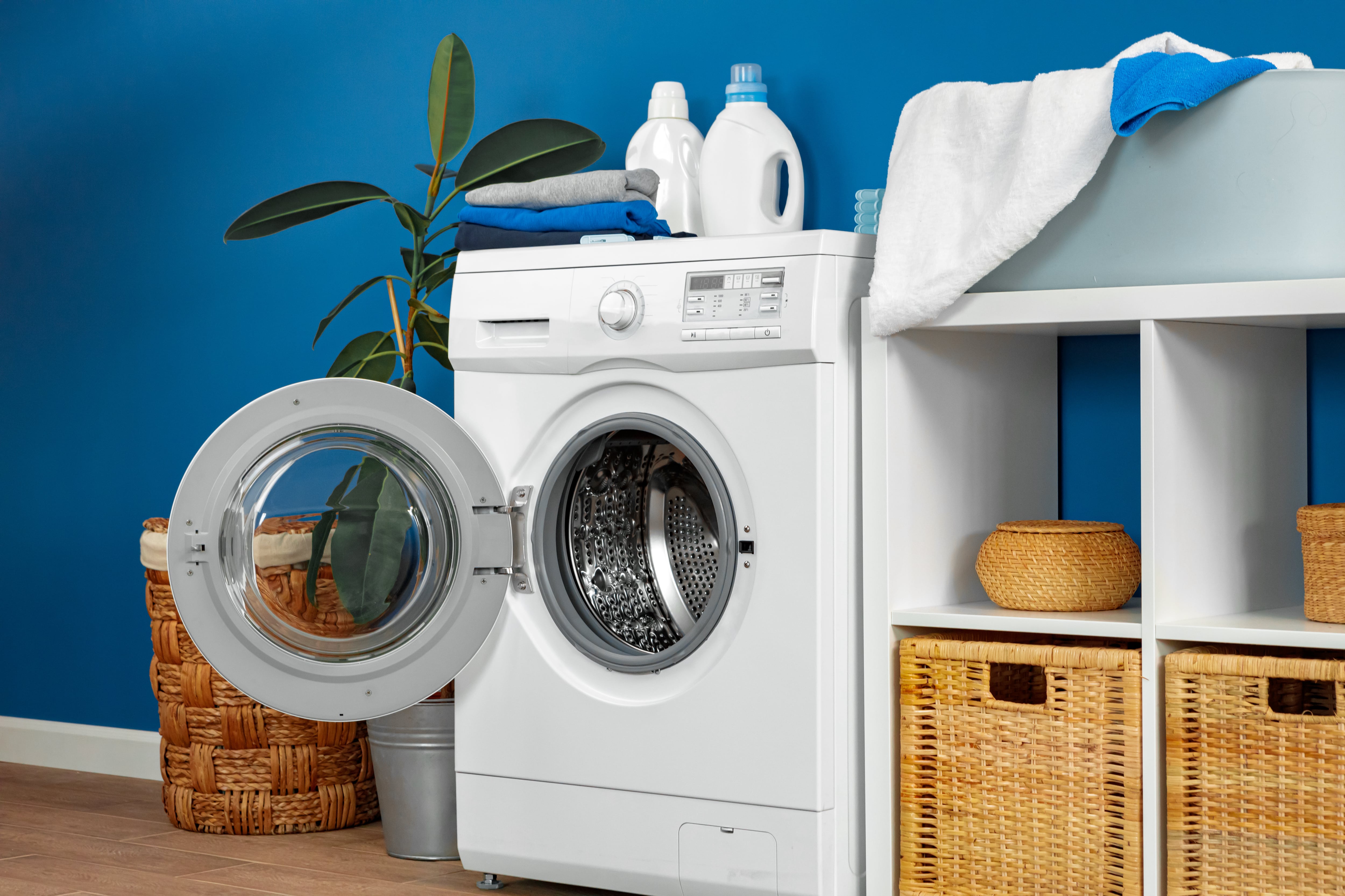 Blue painted laundry room with woven storage bins