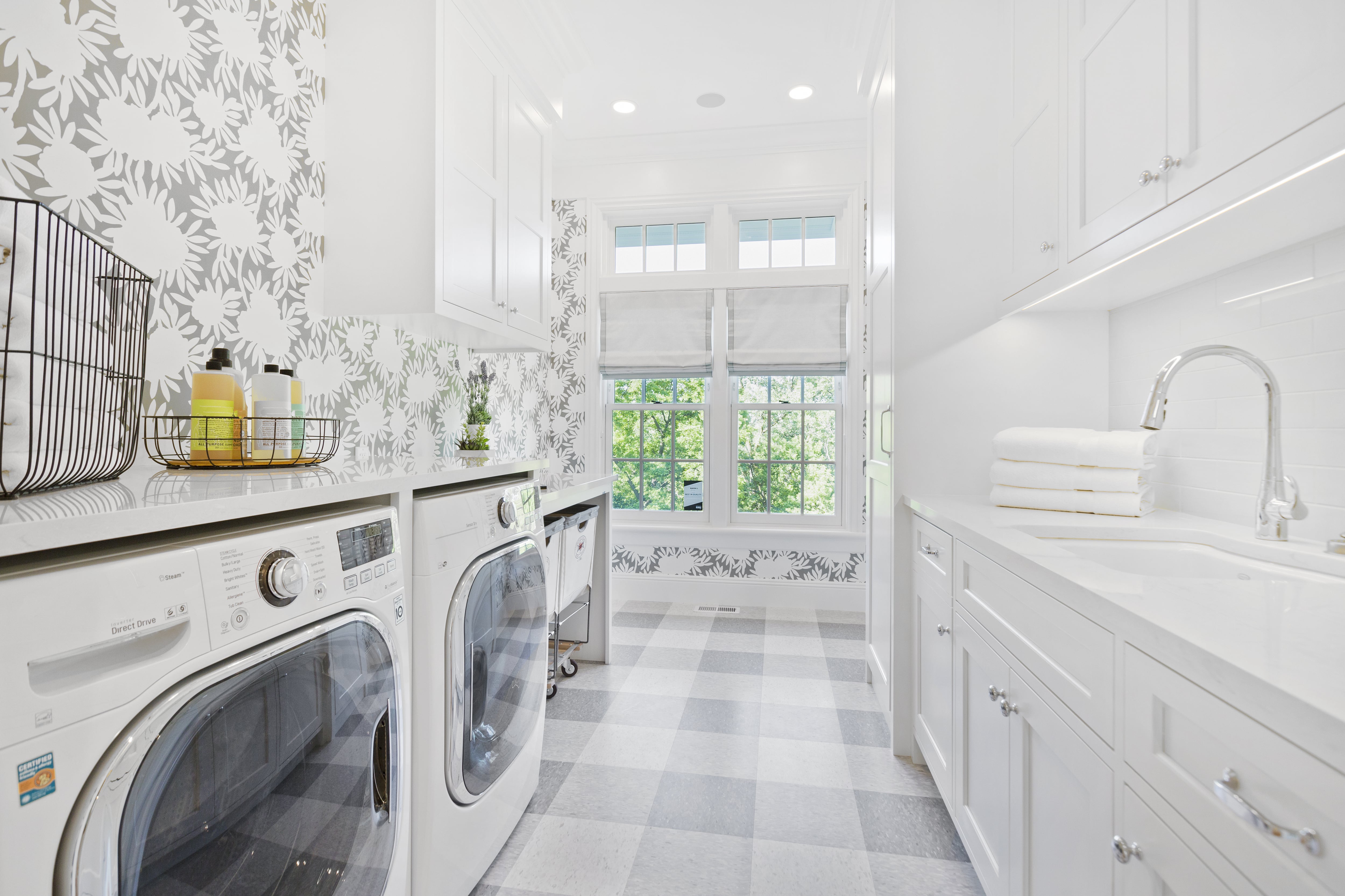 Laundry room with decorative wallpaper and flooring