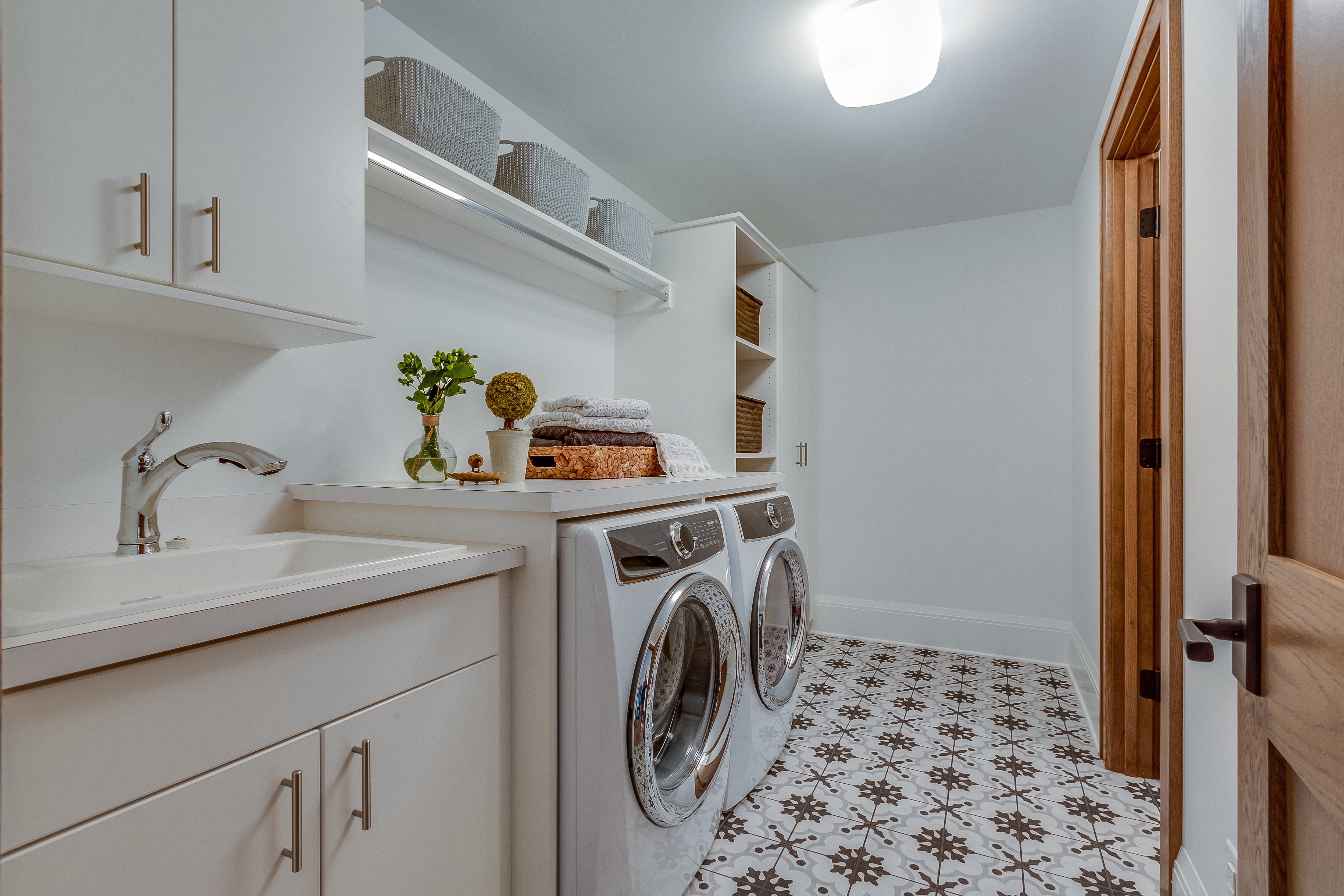 Laundry room with patterned tile flooring