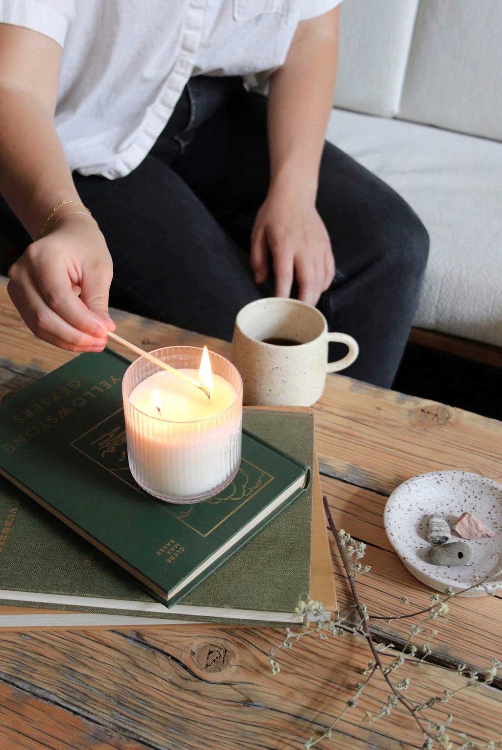 Lighting a candle on a table with a match