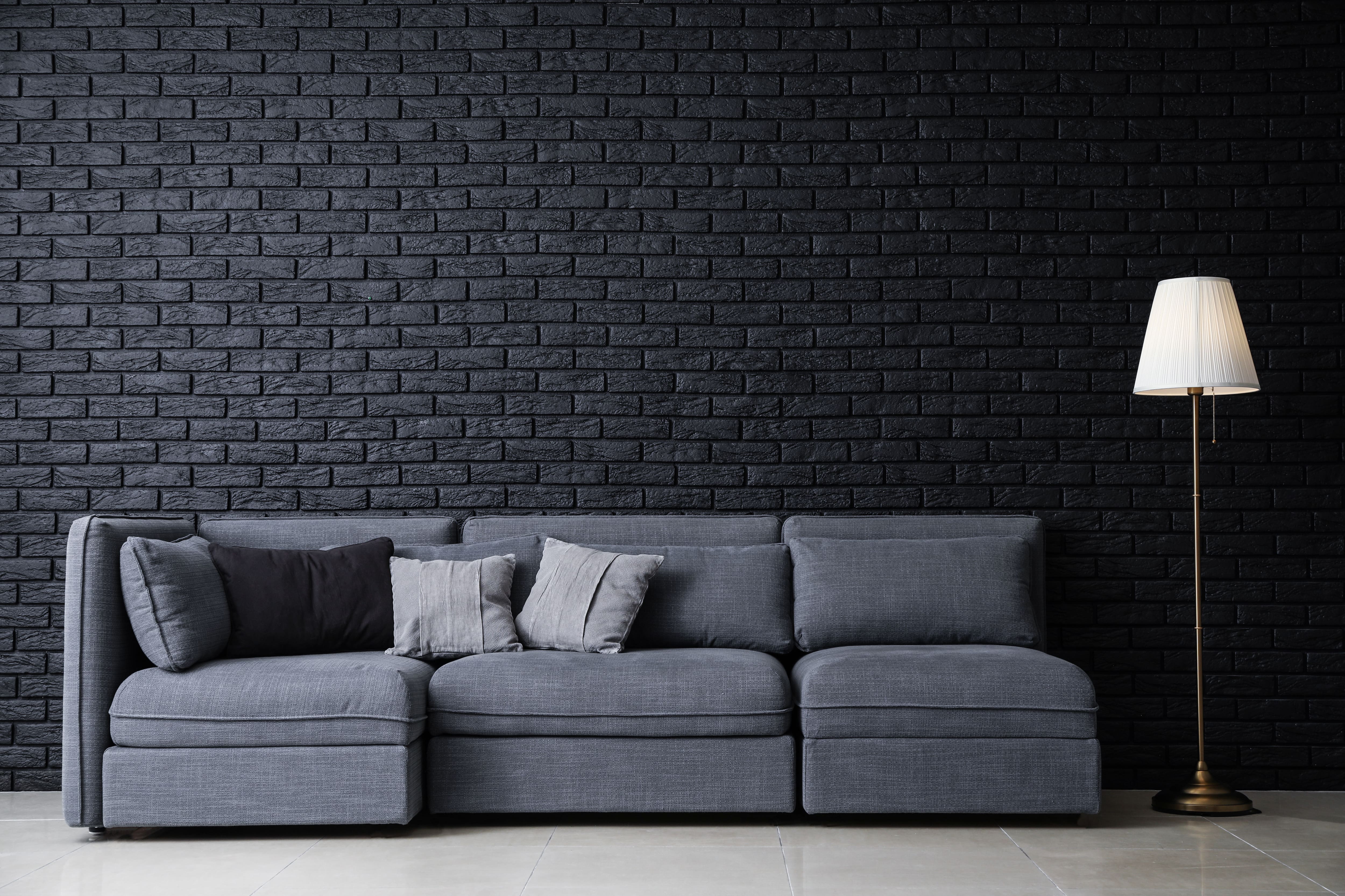 gray couch with decorated hanging shelves in the background