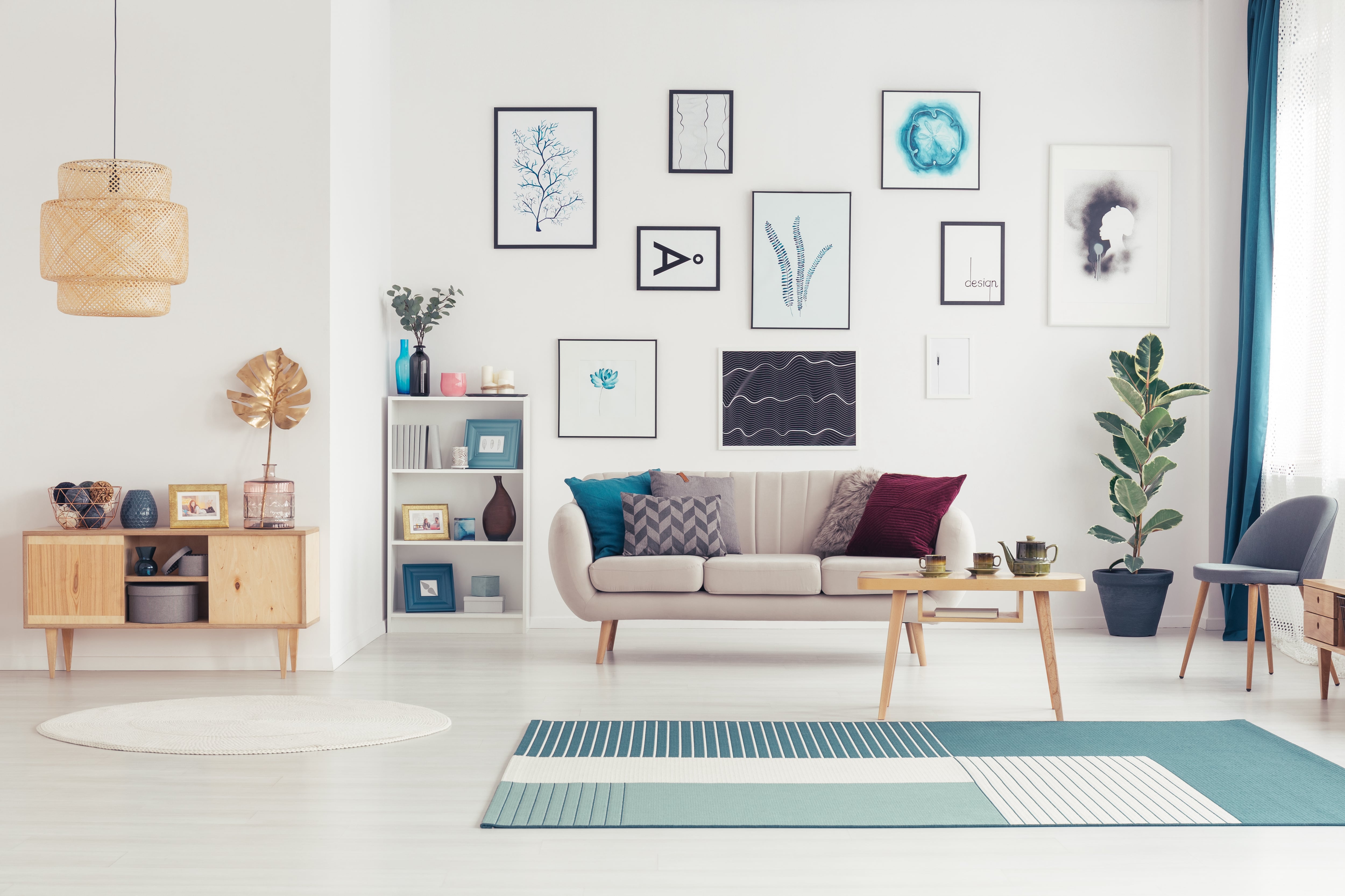 Living room with grey couch, blue rug, and a gallery wall