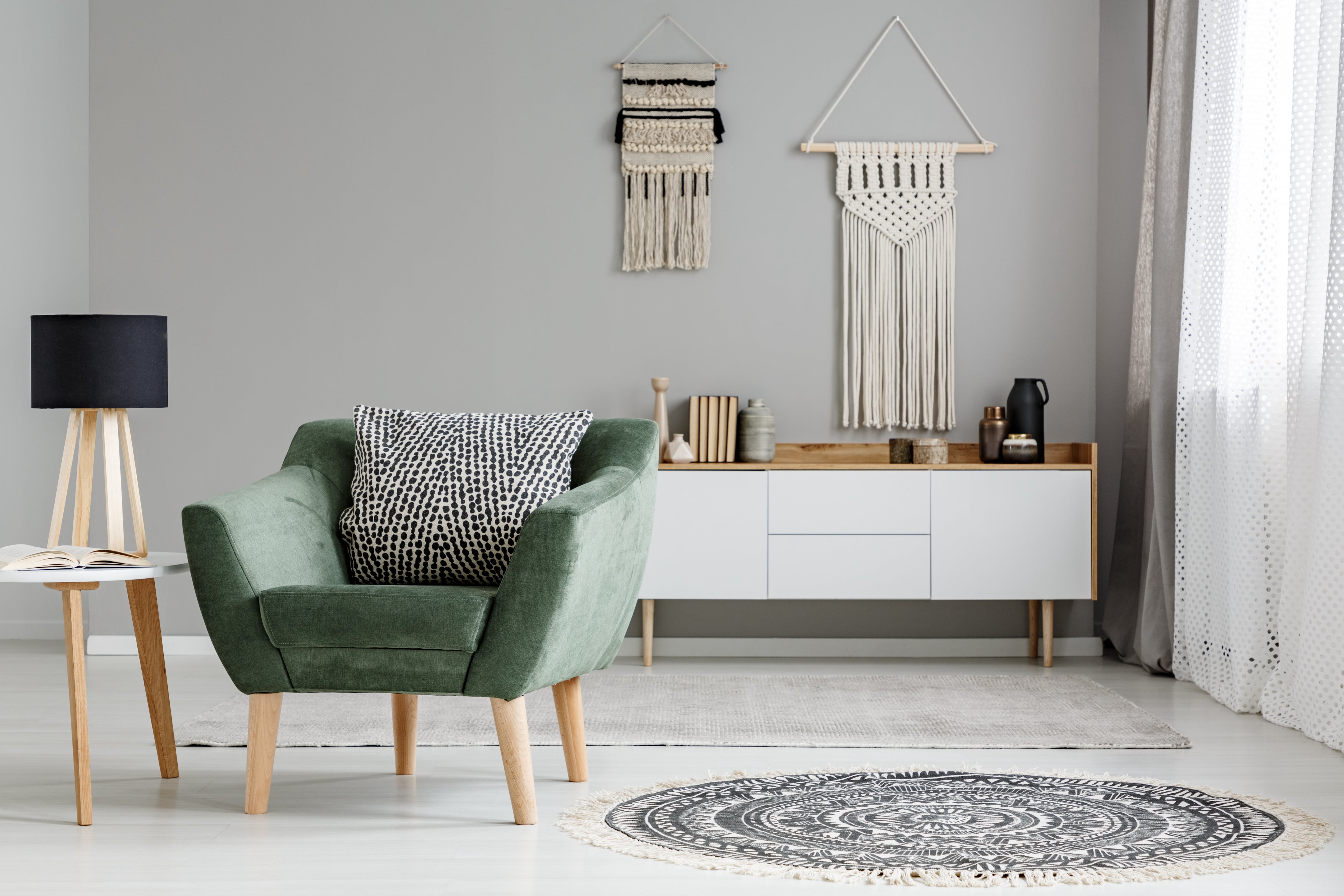 Green chair with macrame hangings in the background 