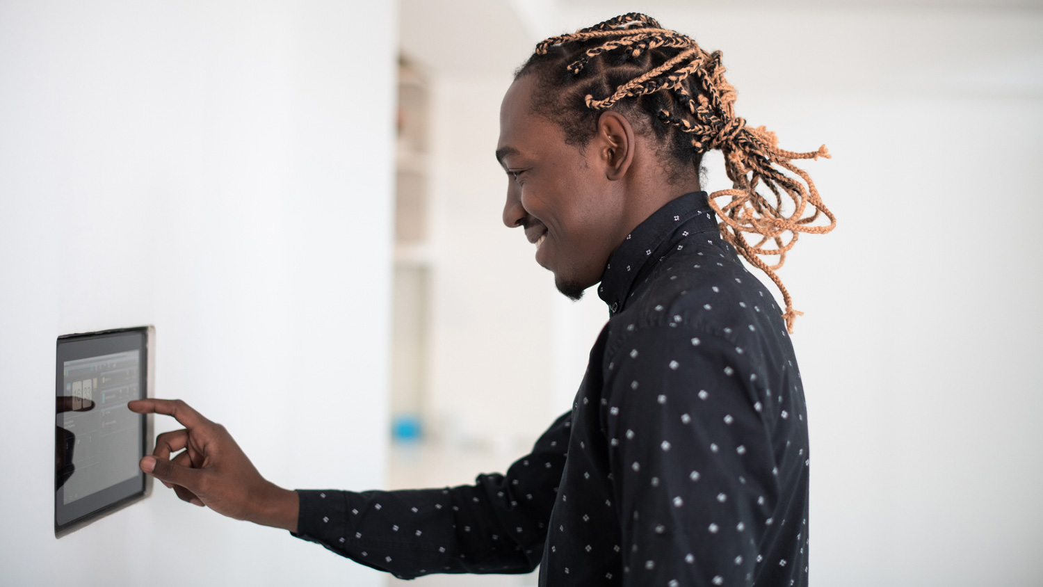 A man adjusting the thermostat’s temperature