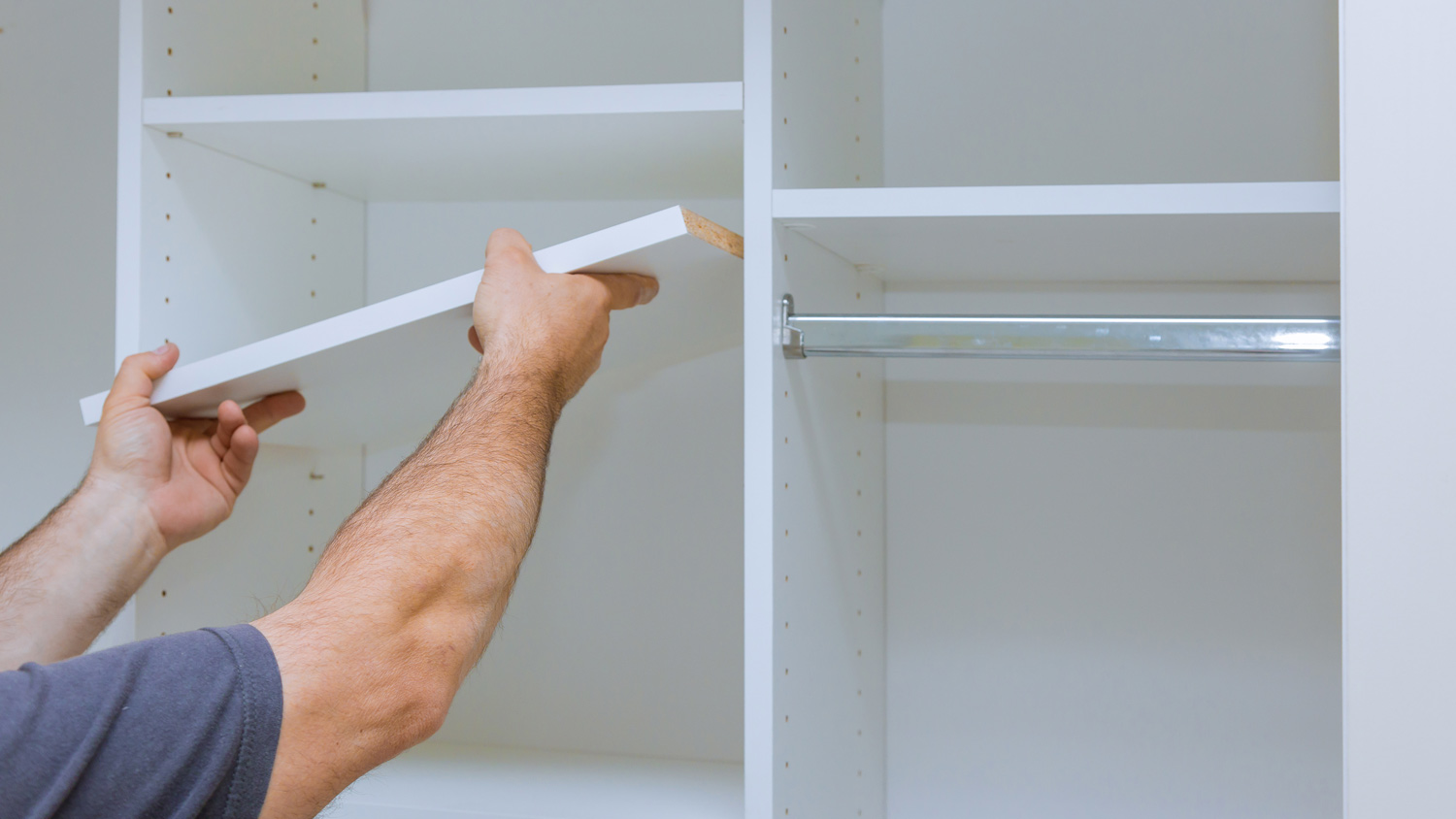 A man assembling a closet unit