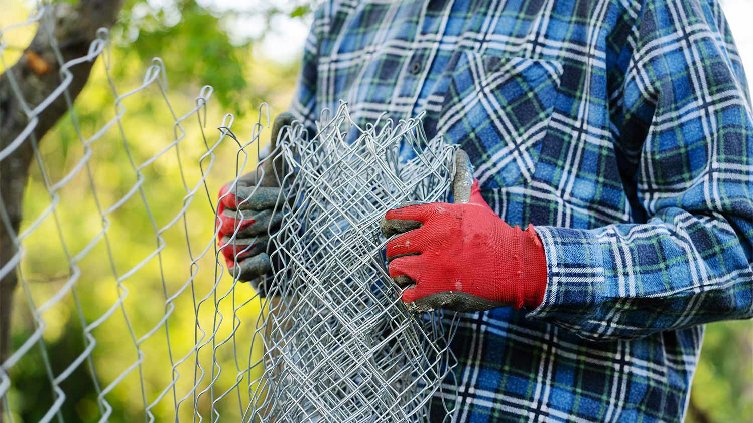 man in yard with wire fence